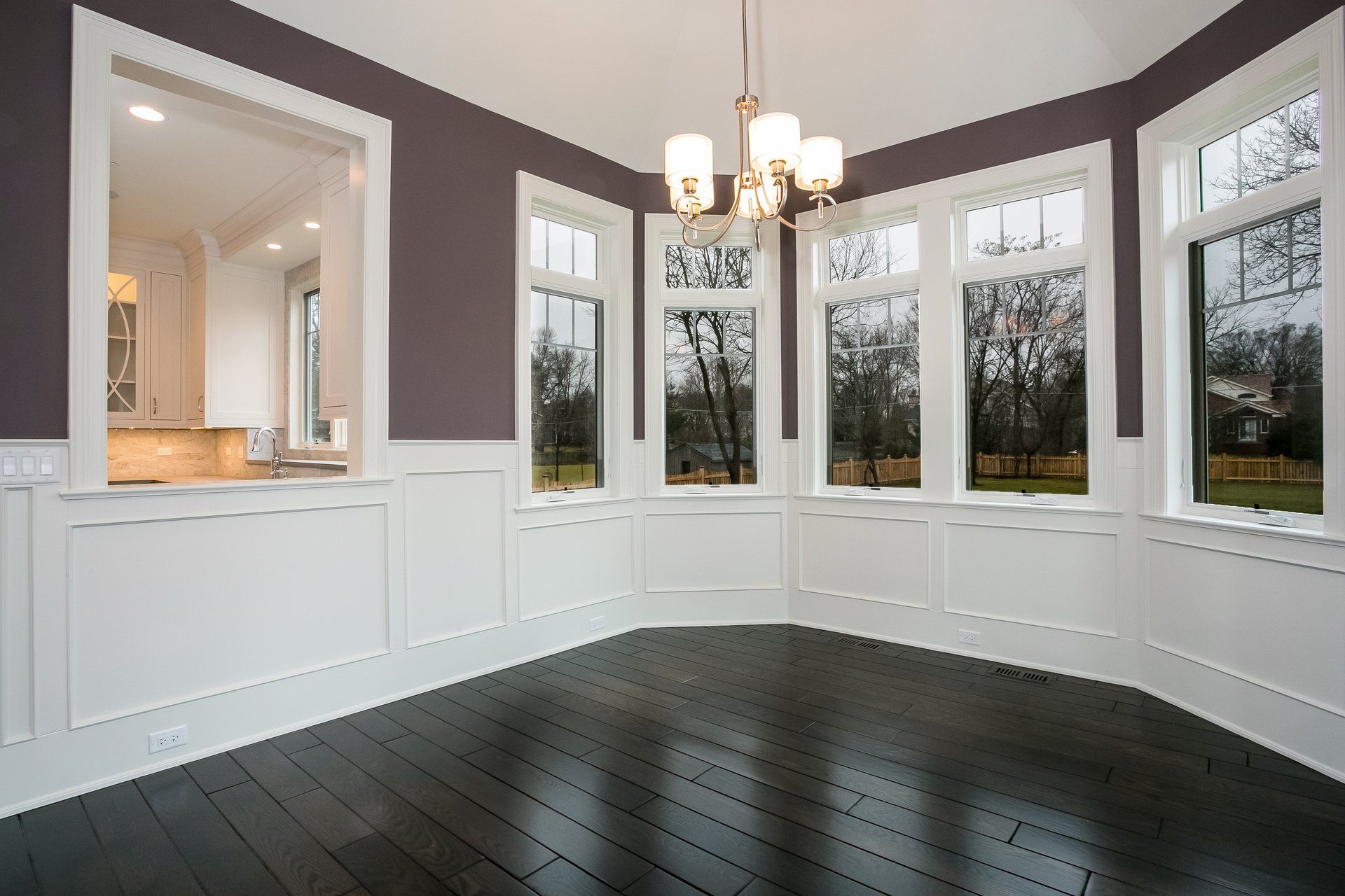 An empty room with a lot of windows and a chandelier