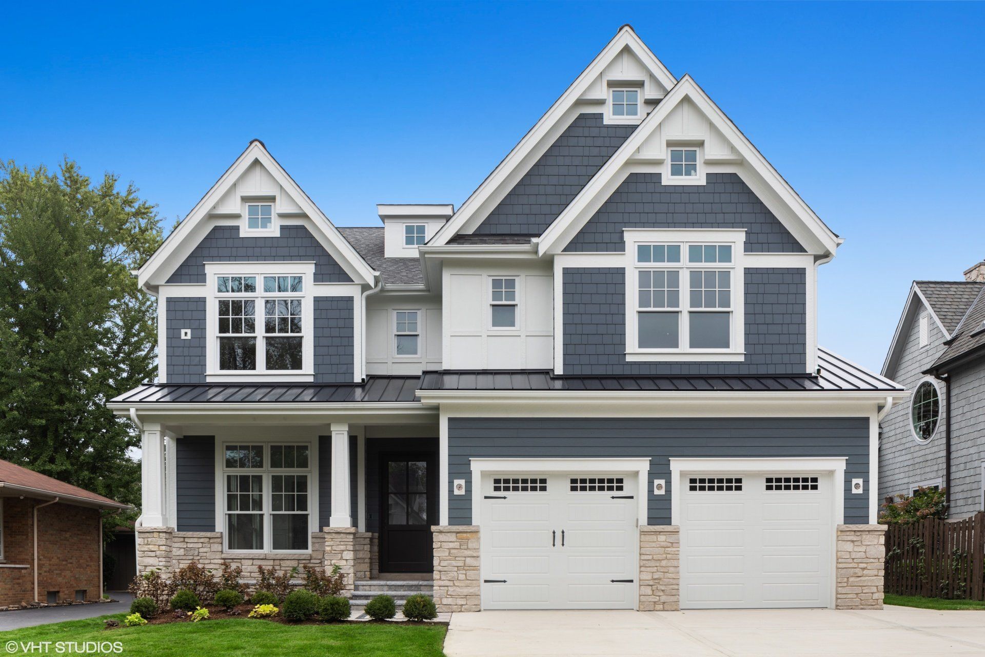 A large house with a blue siding and white trim