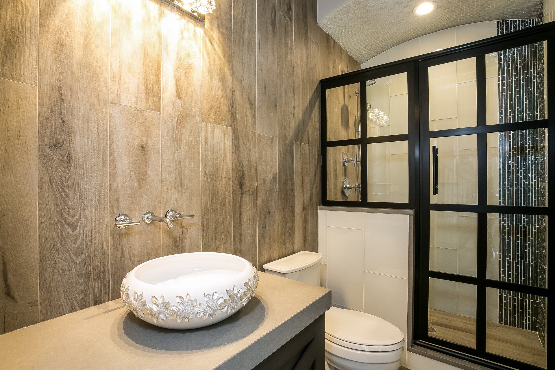 A bathroom with a sink , toilet and shower.