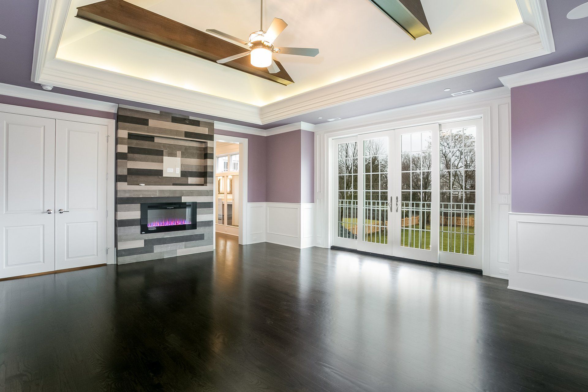 An empty living room with a fireplace and a ceiling fan.