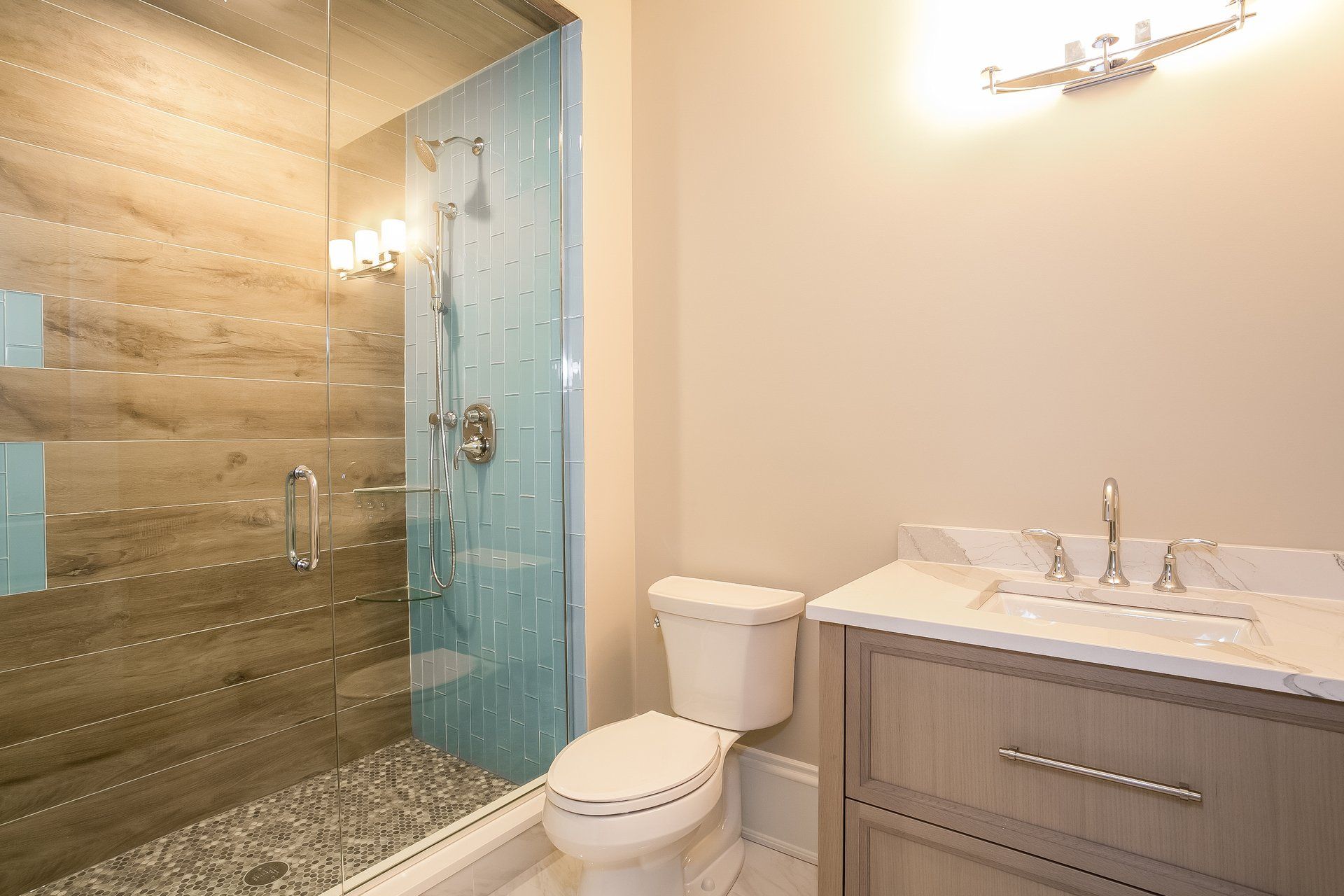 A bathroom with a toilet , sink , and walk in shower.