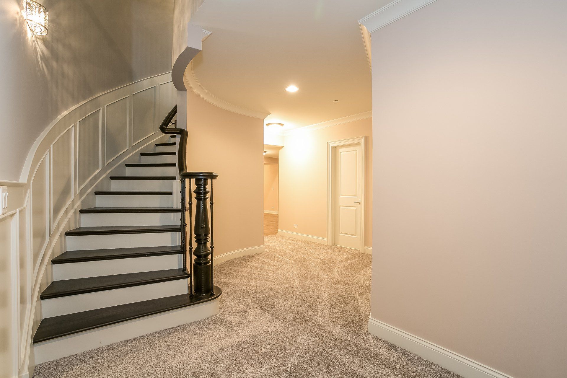 There is a curved staircase in the middle of the hallway.