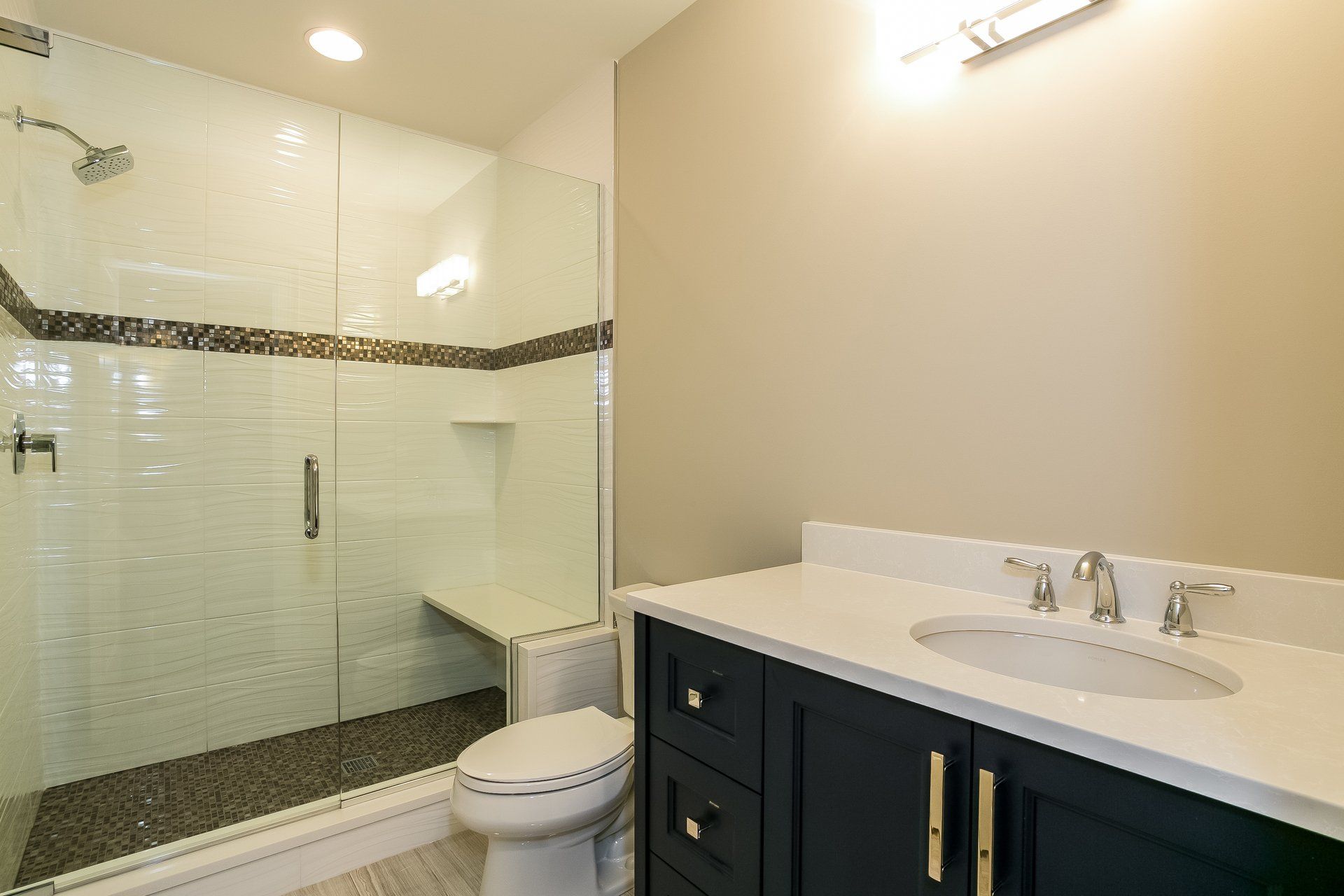 A bathroom with a toilet , sink , and walk in shower.