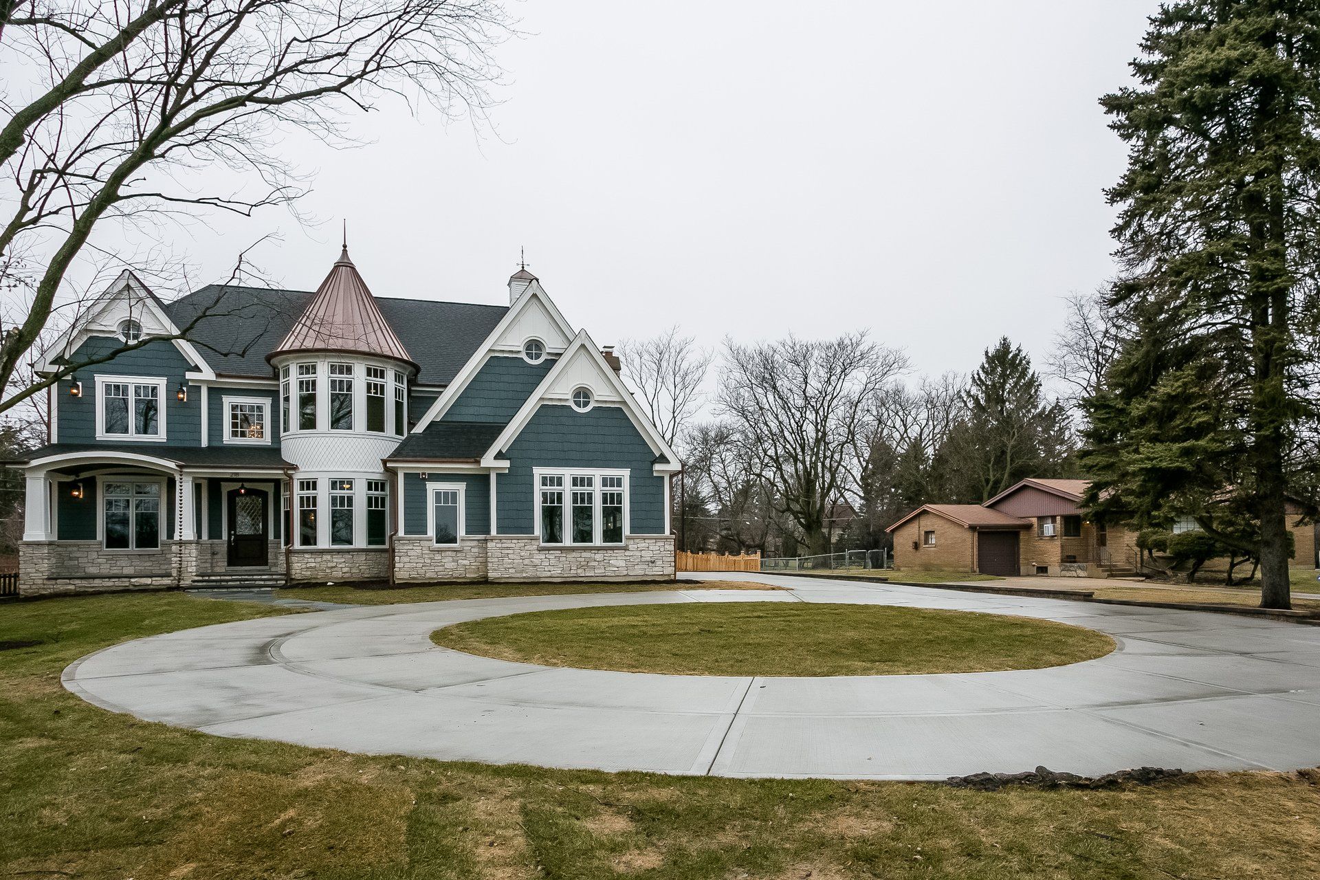 A large house with a circular driveway in front of it.