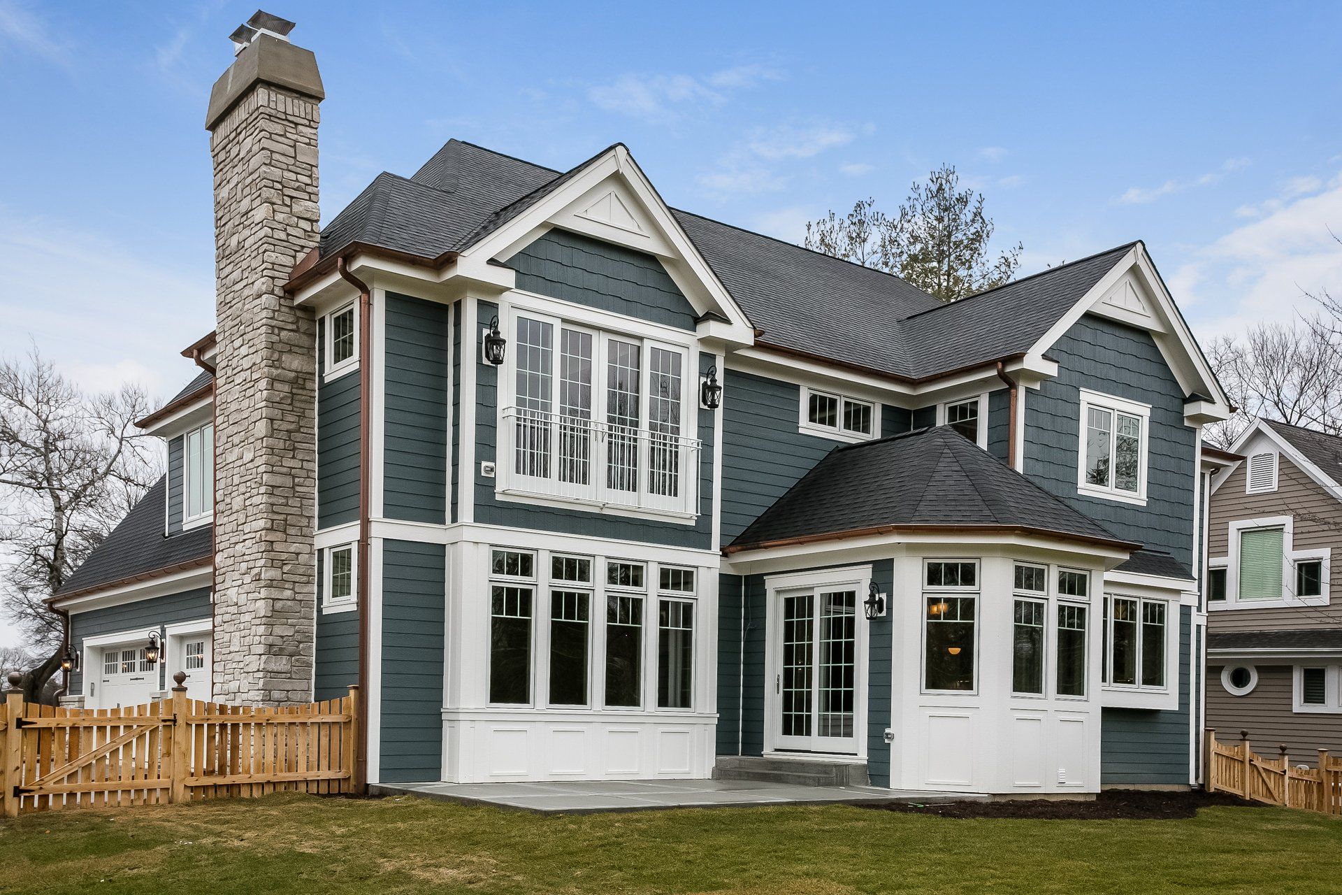 A large house with a lot of windows and a chimney.