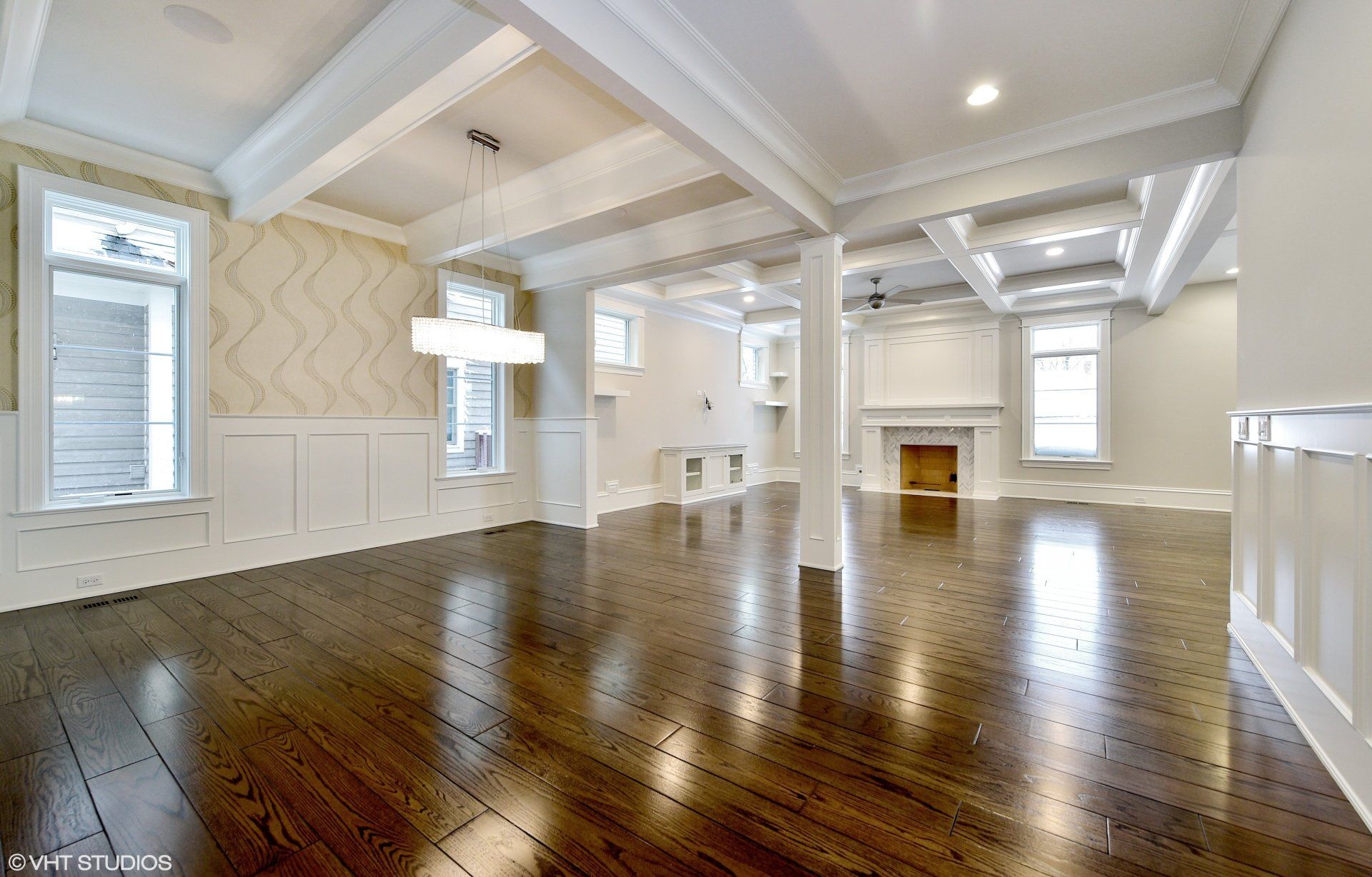 An empty living room with hardwood floors and a fireplace.