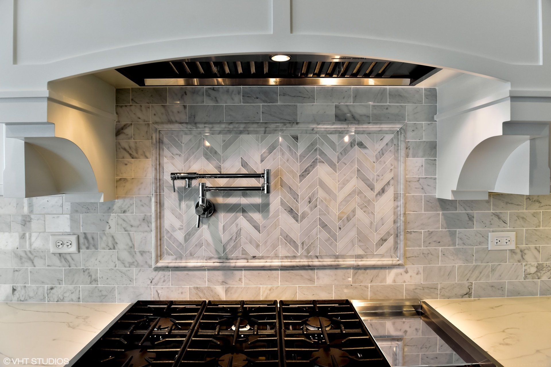 A kitchen with a stove top oven and a hood