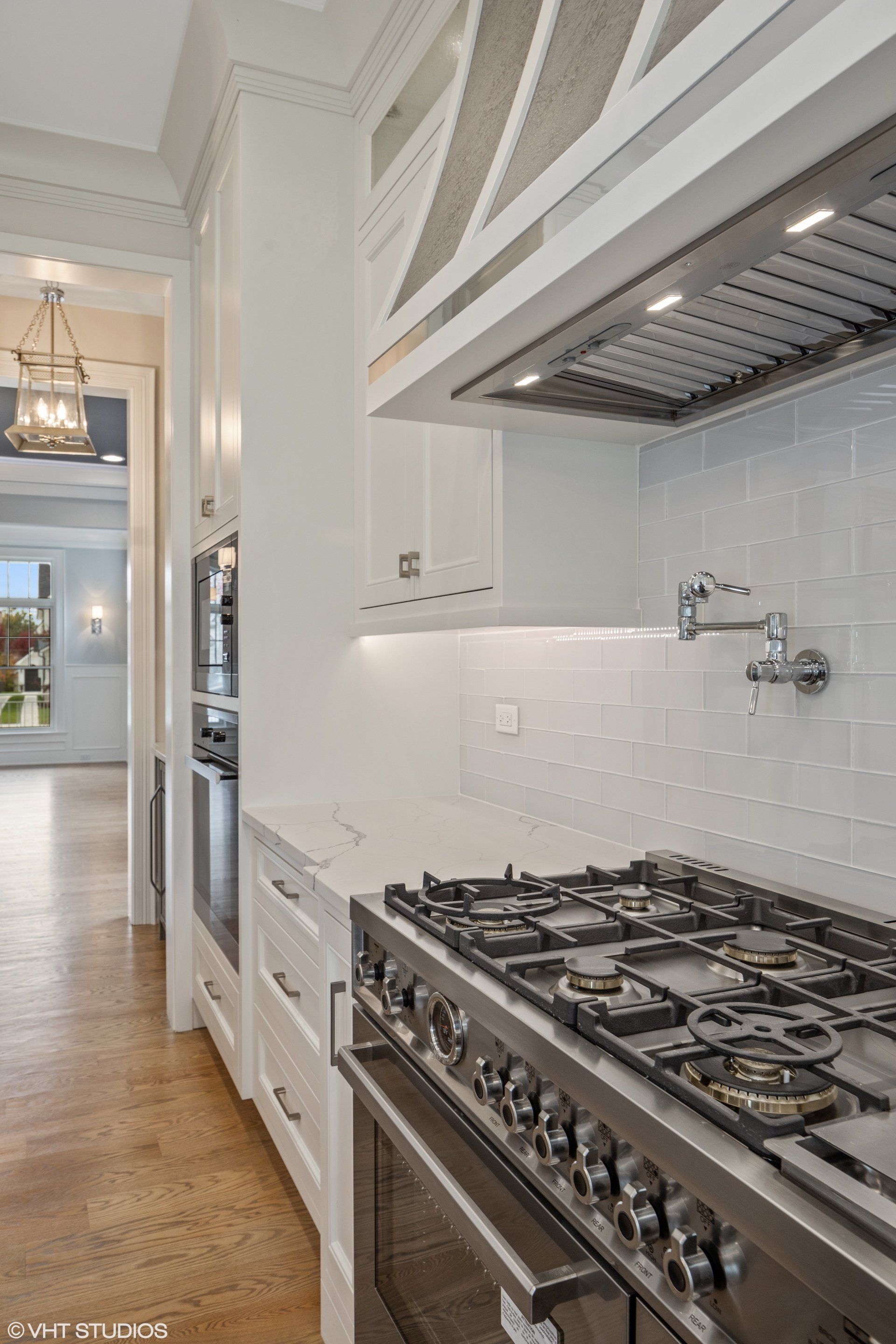A kitchen with a stove top oven and a sink.
