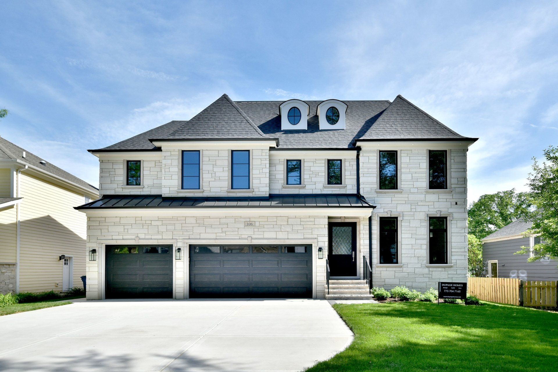 A large white brick house with a gray garage door