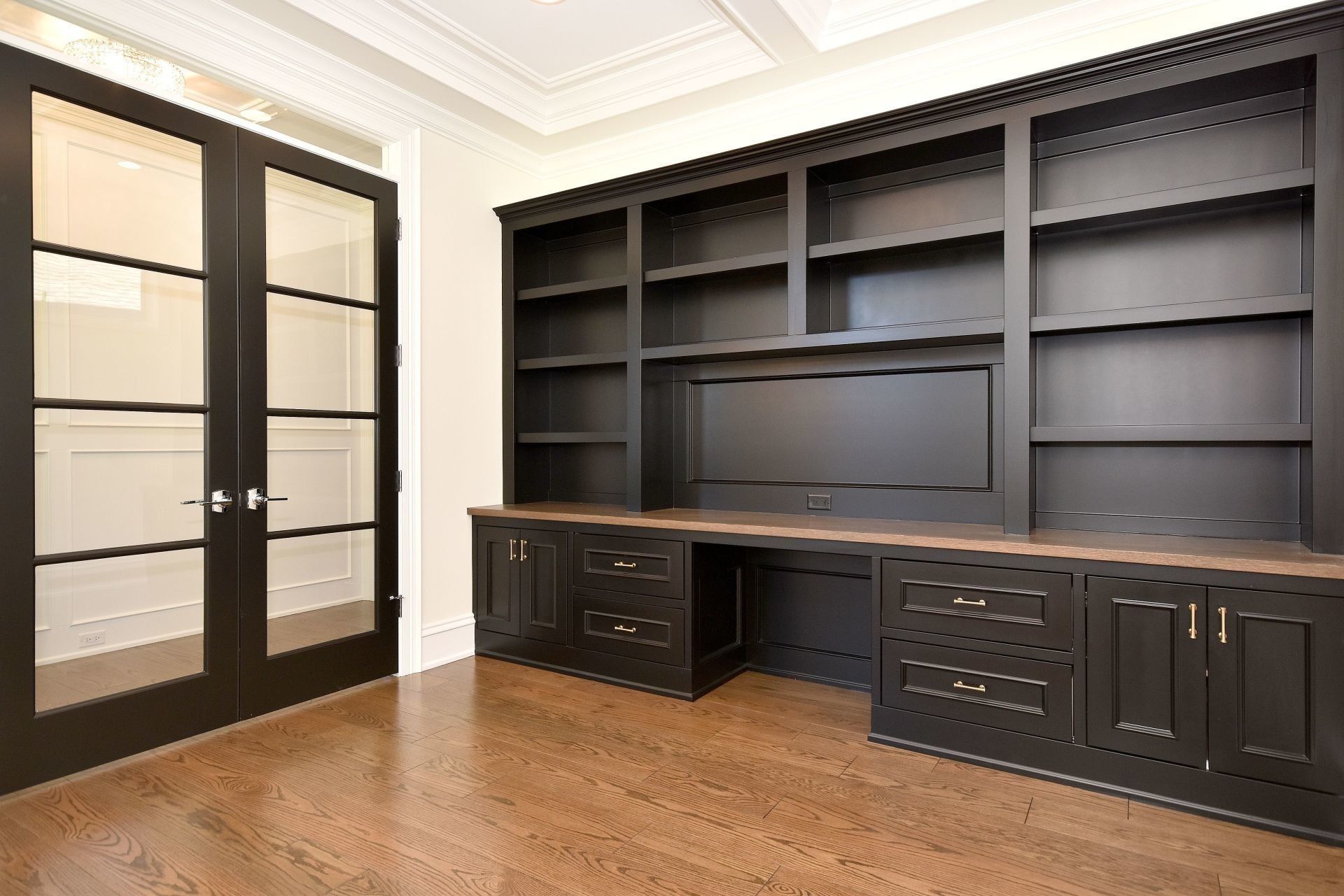 A large empty room with black cabinets and shelves