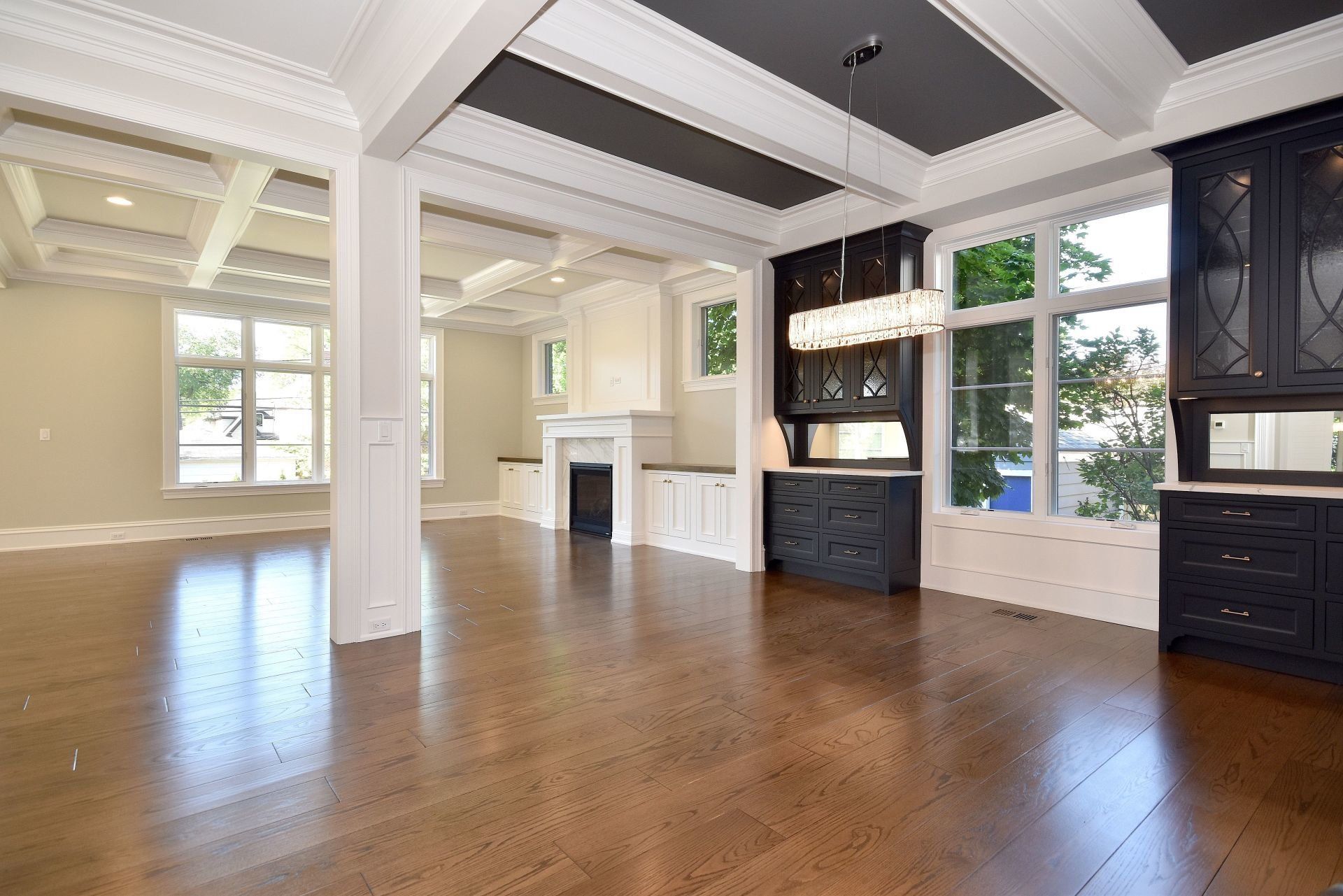 A large empty room with hardwood floors and a fireplace.