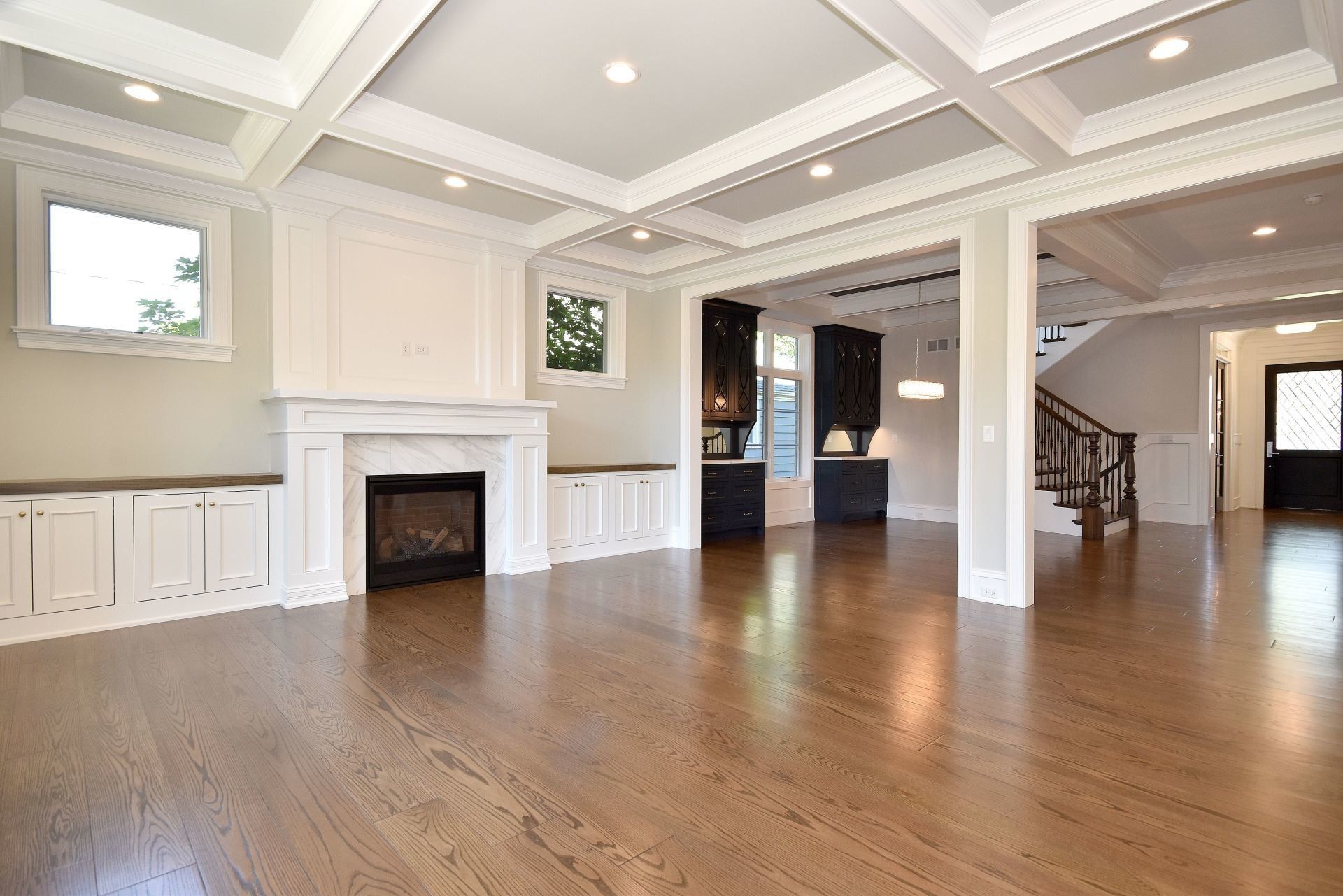 An empty living room with hardwood floors and a fireplace.
