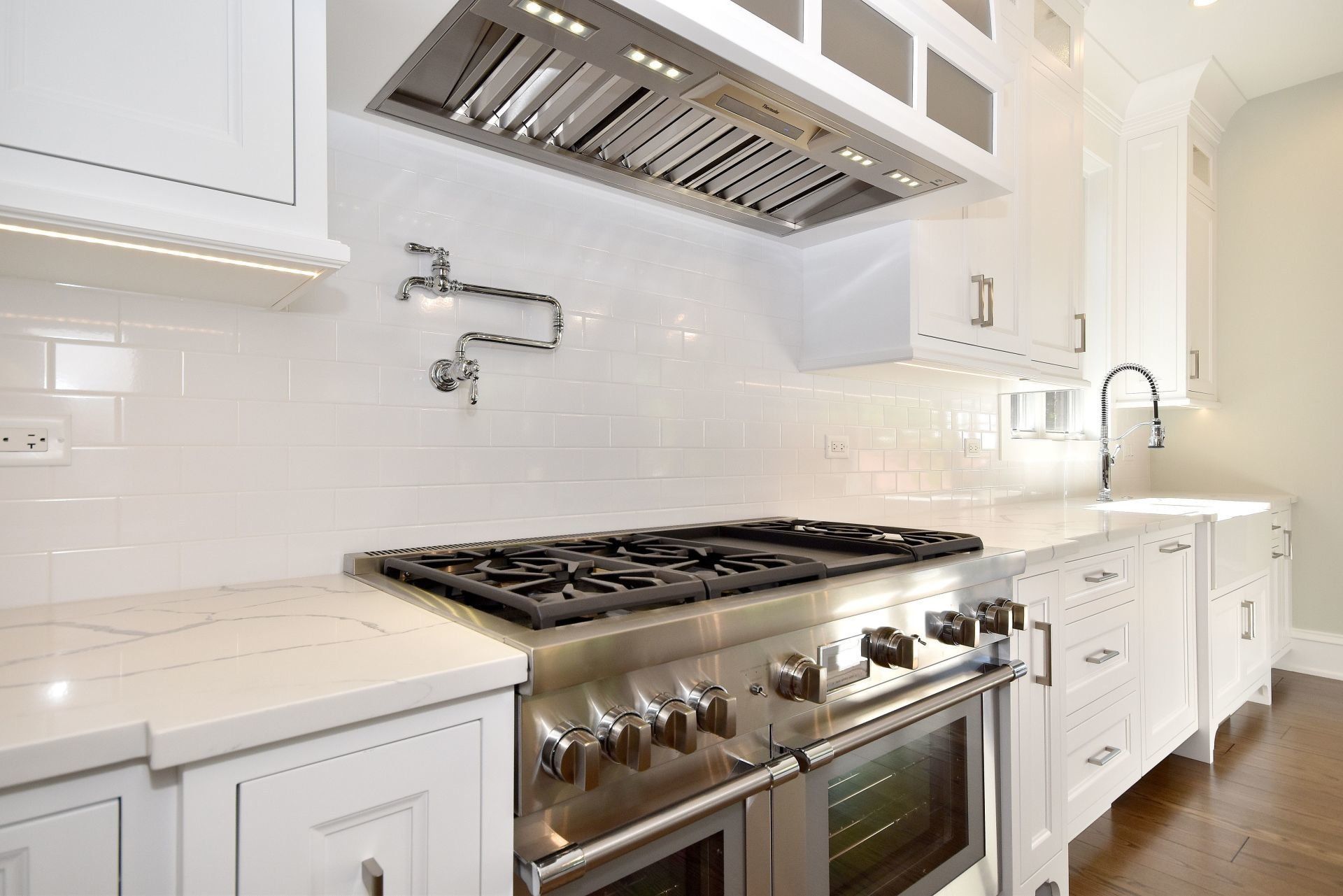 A kitchen with stainless steel appliances and white cabinets.