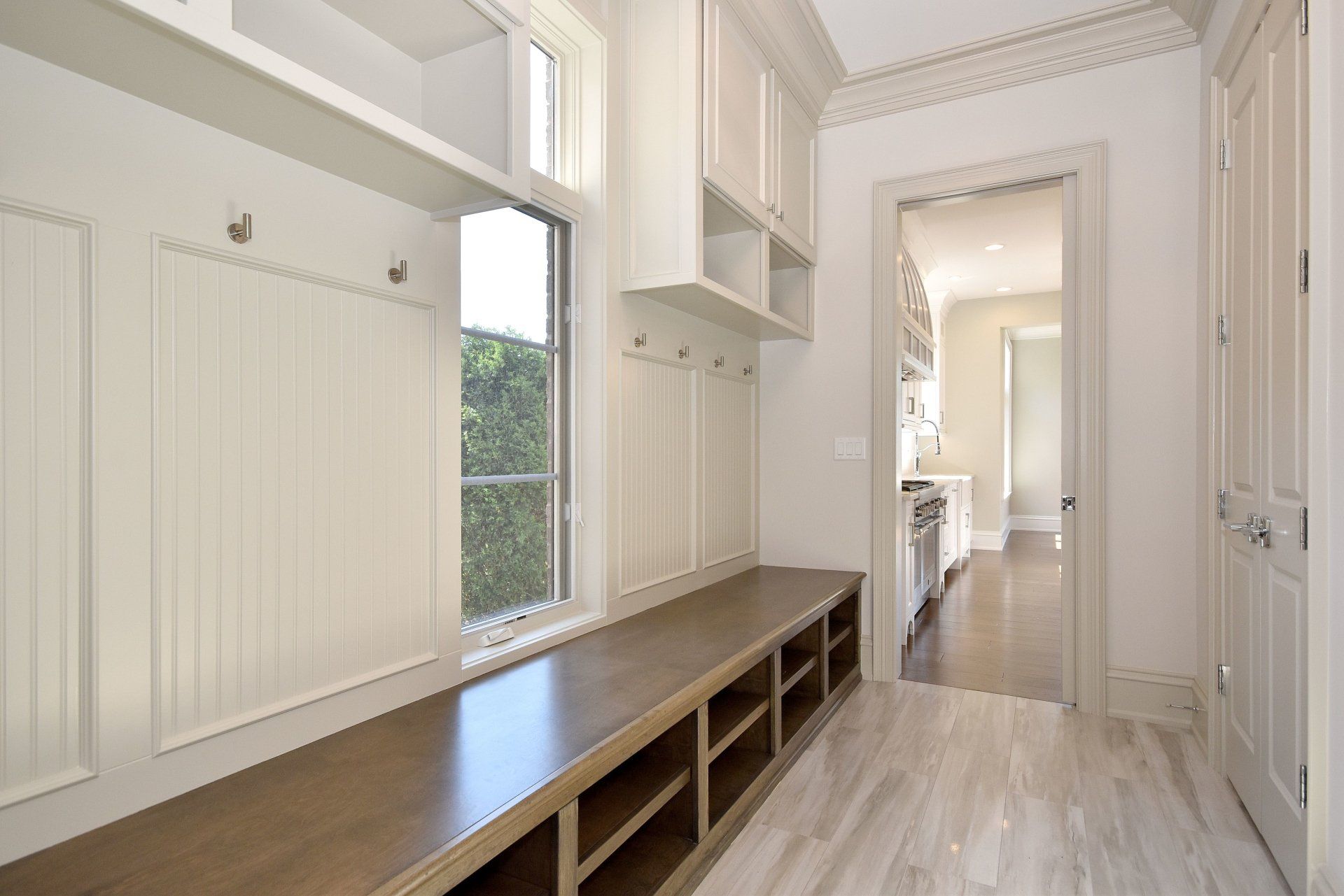 A hallway with a bench and a window in a house.