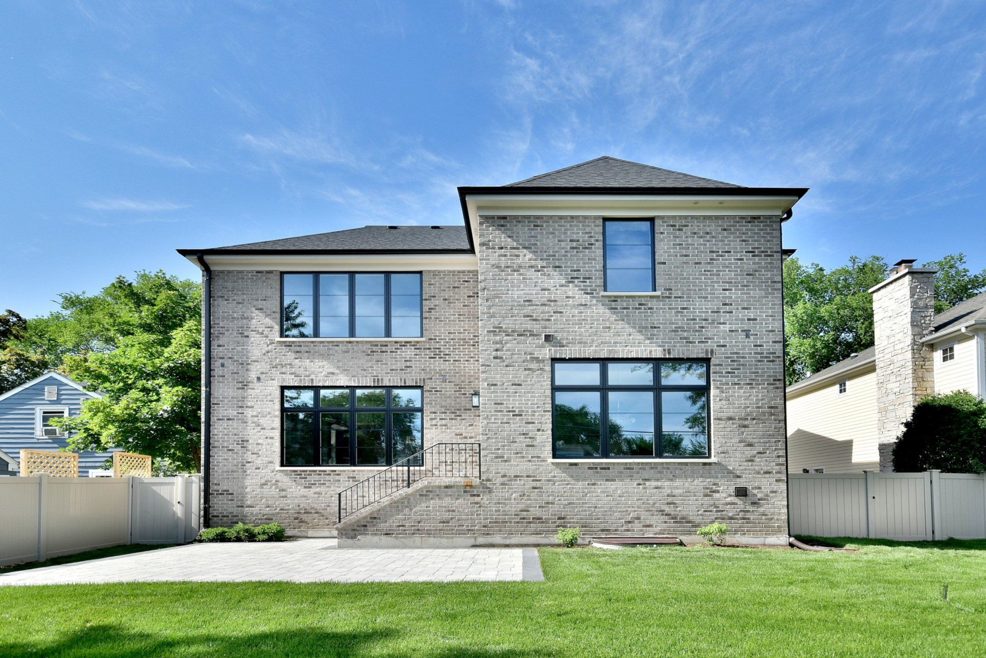 The back of a large brick house with a lot of windows