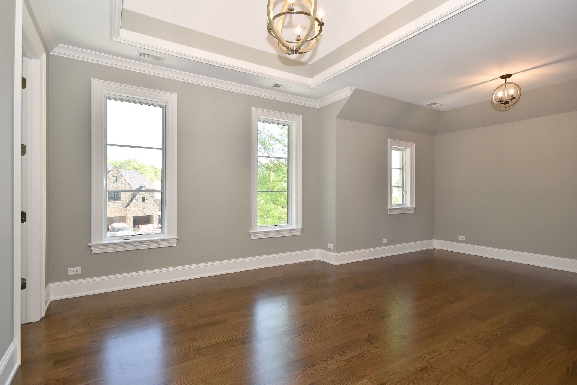 An empty room with hardwood floors and gray walls