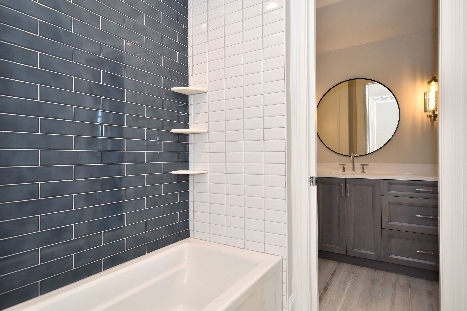 A bathroom with a bathtub , sink and mirror.