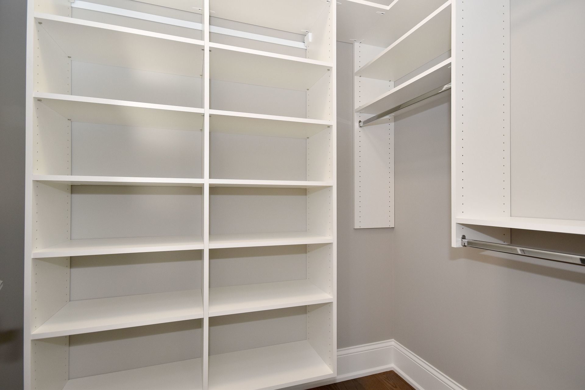 A walk in closet with lots of shelves and hanging racks.