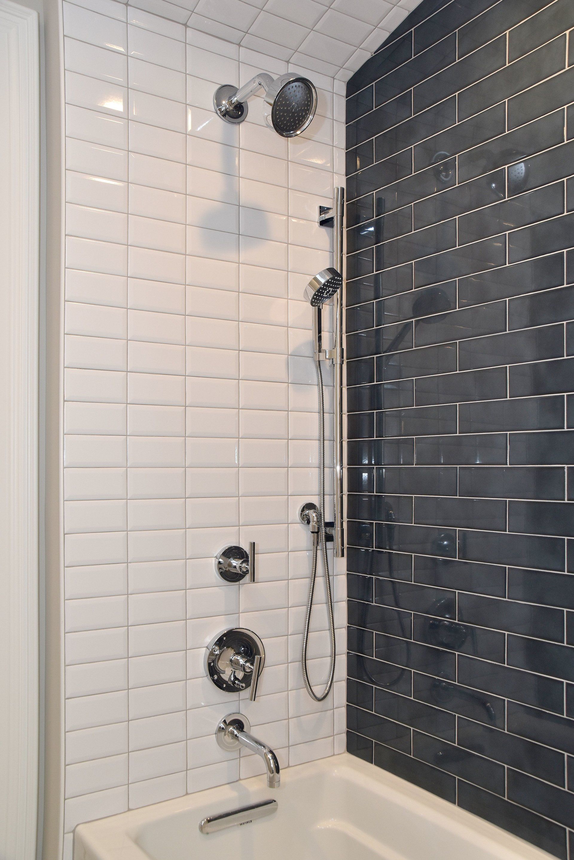A bathroom with black and white tiles and a bathtub.