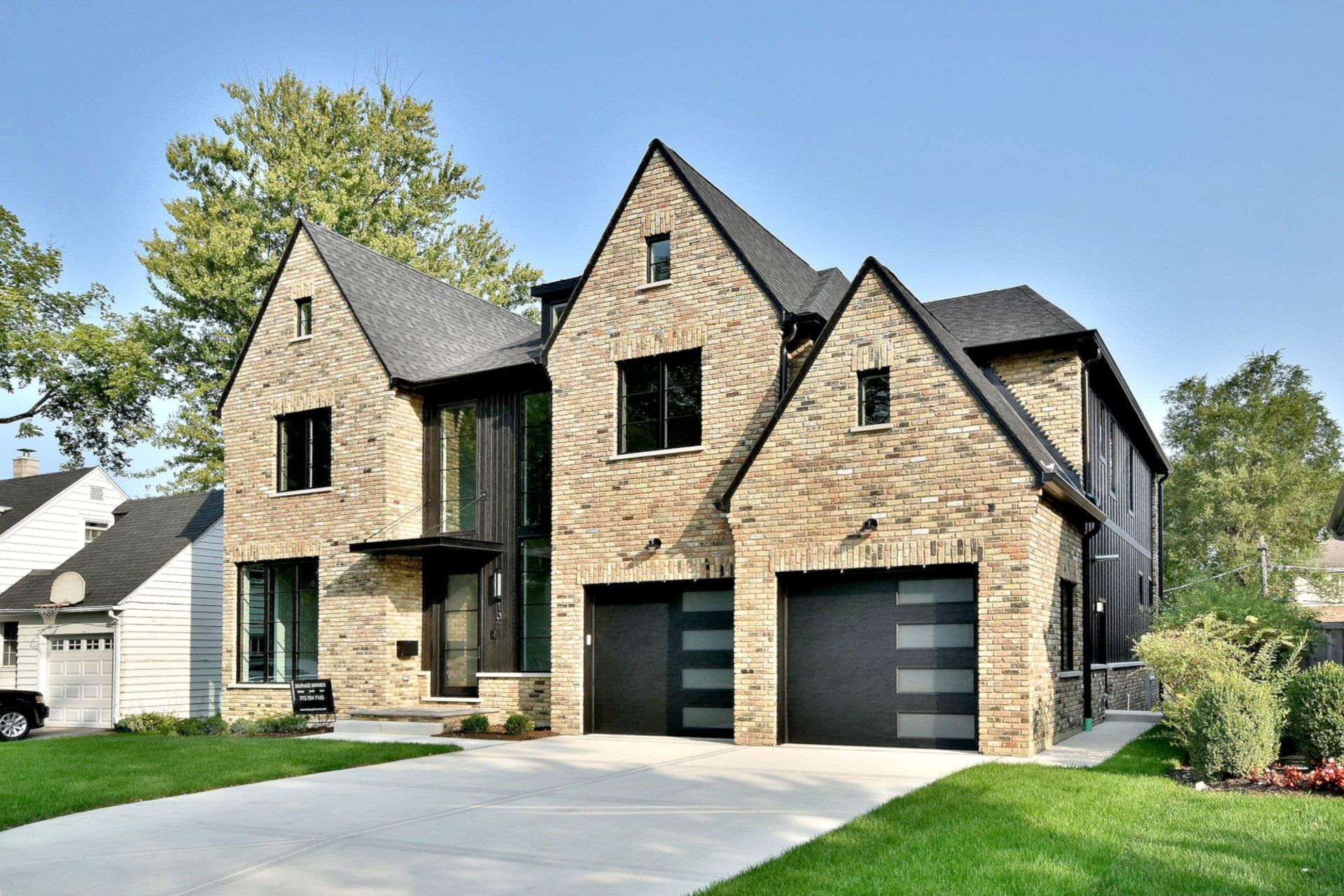 A large brick house with two garages and a driveway.