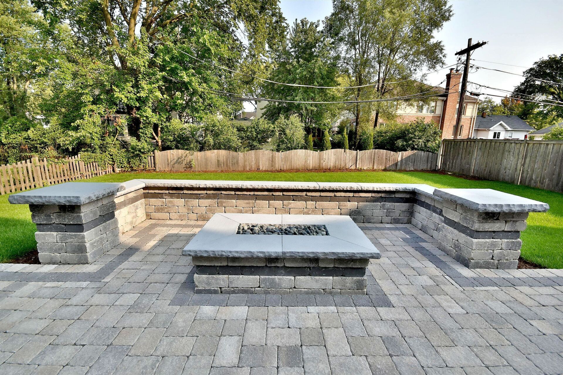 A brick patio with a fire pit in the middle