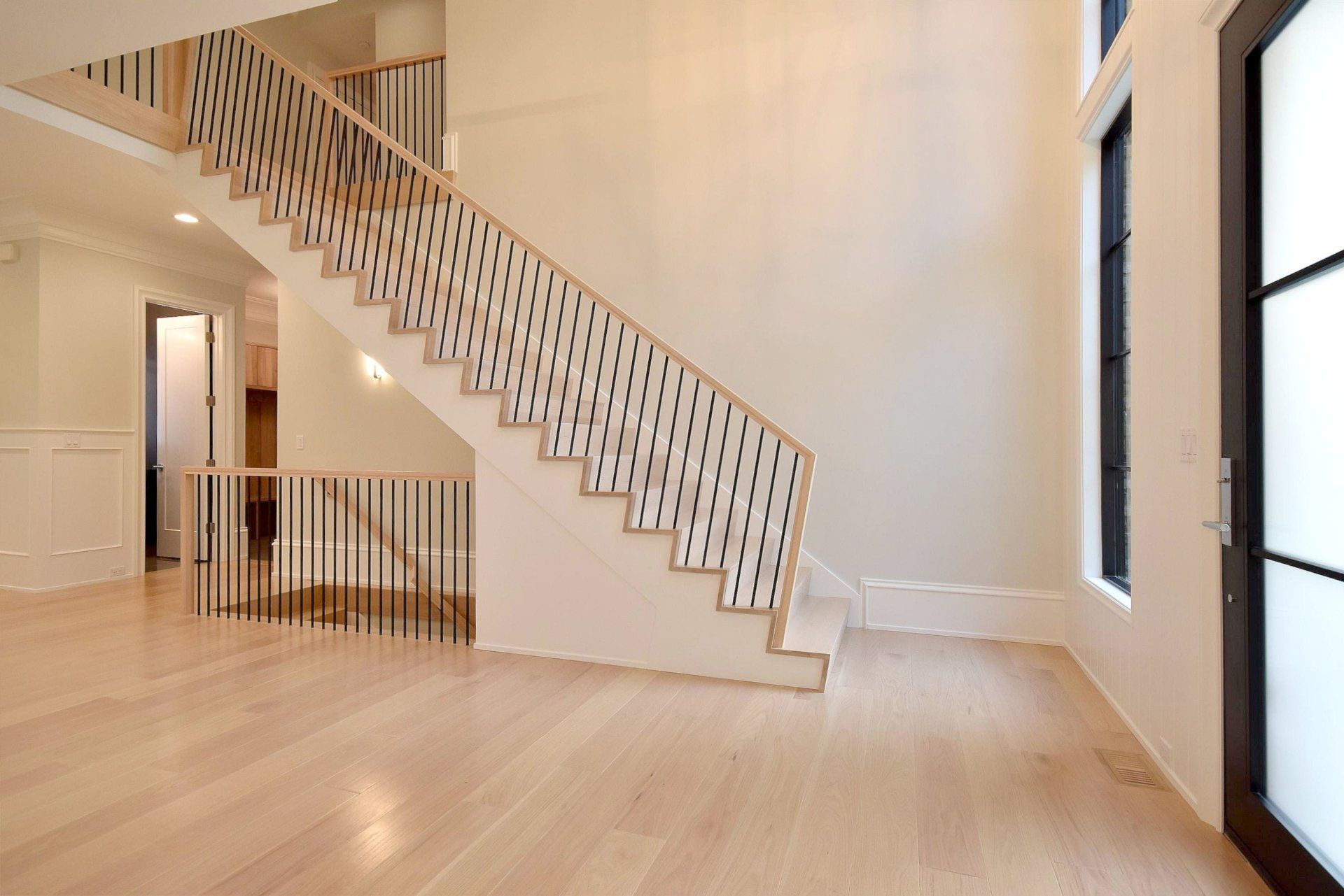 An empty room with a staircase and a door