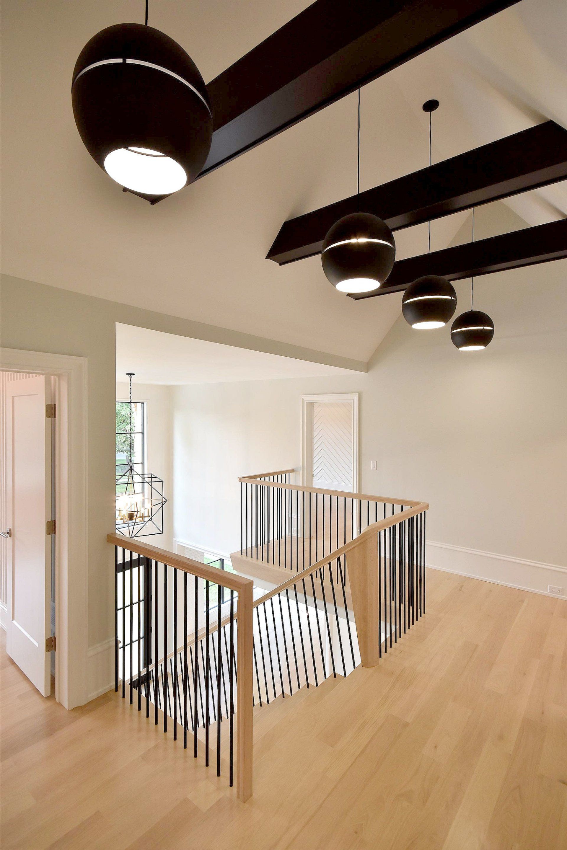 There is a staircase in the middle of the room with a wooden railing.