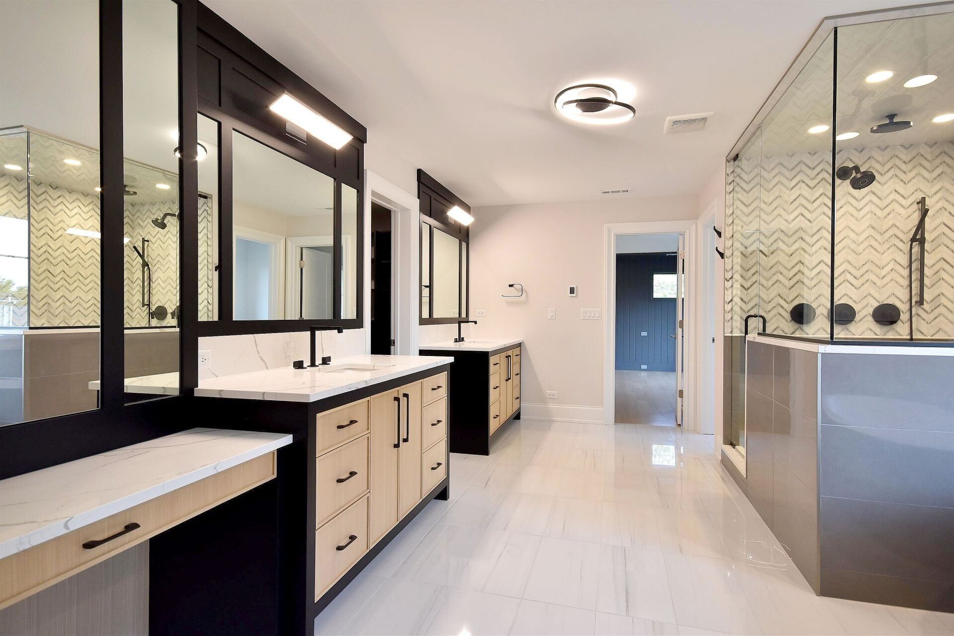 A bathroom with two sinks , a tub , and a walk in shower.