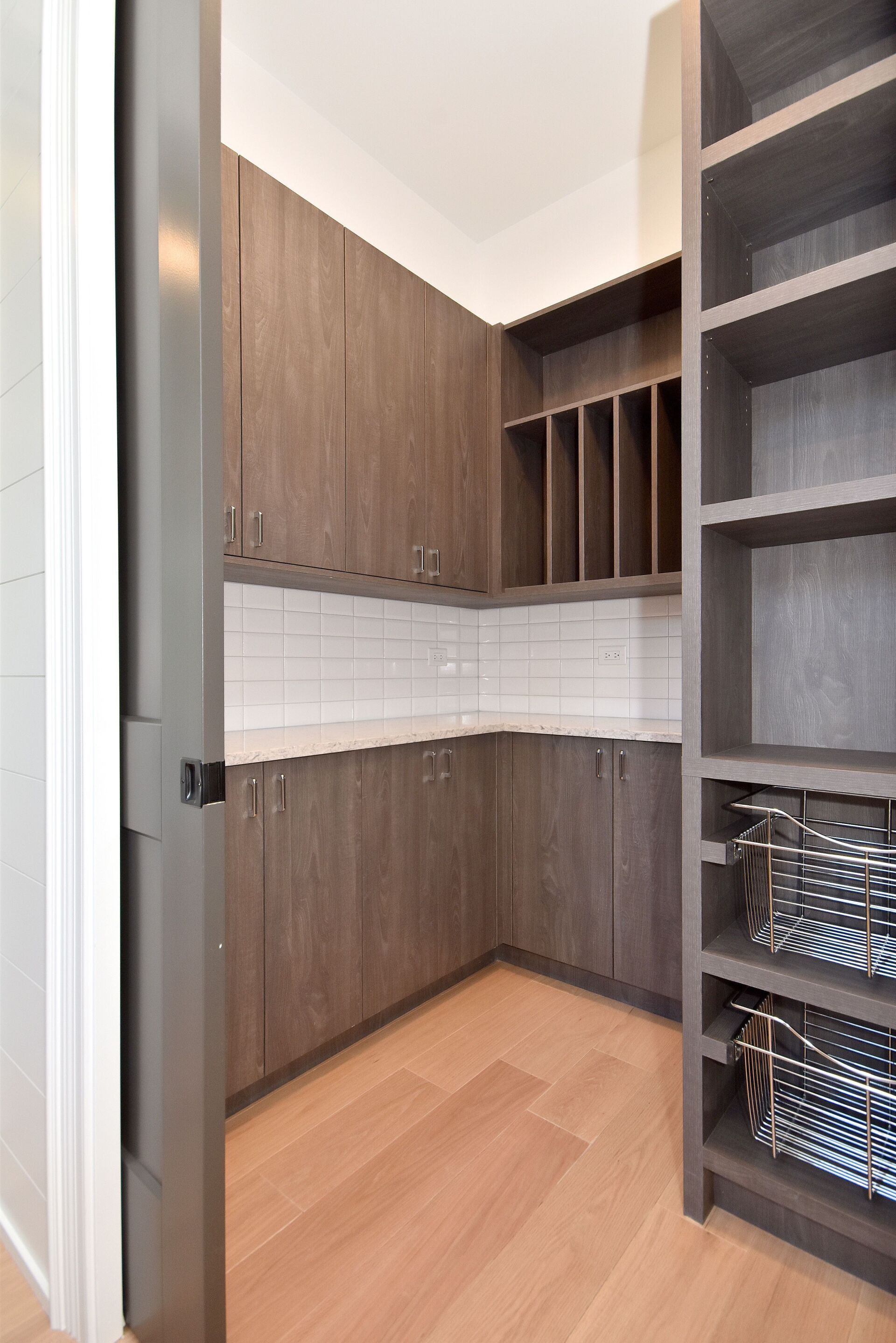 A kitchen with wooden cabinets and lots of shelves