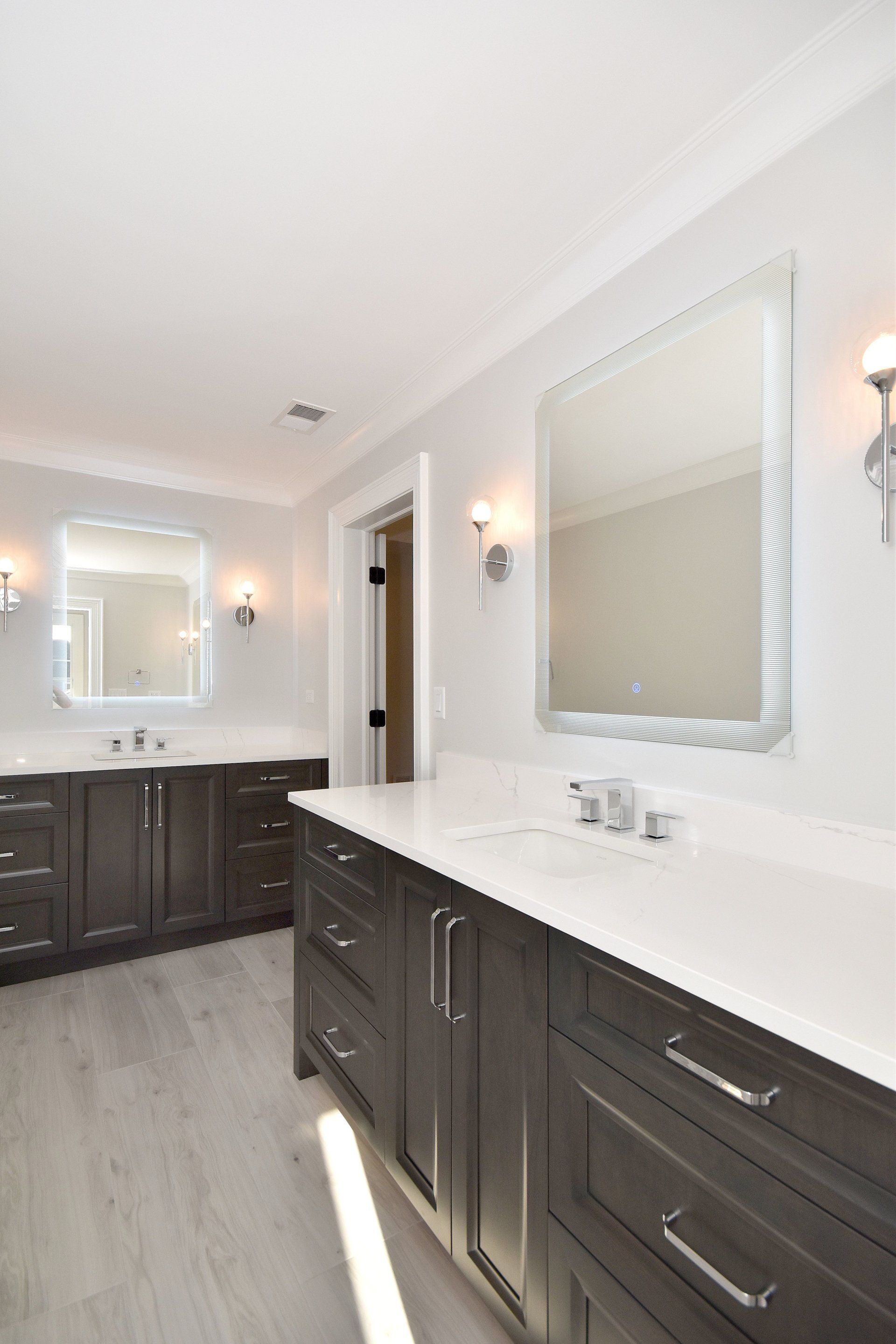A bathroom with two sinks and a large mirror.