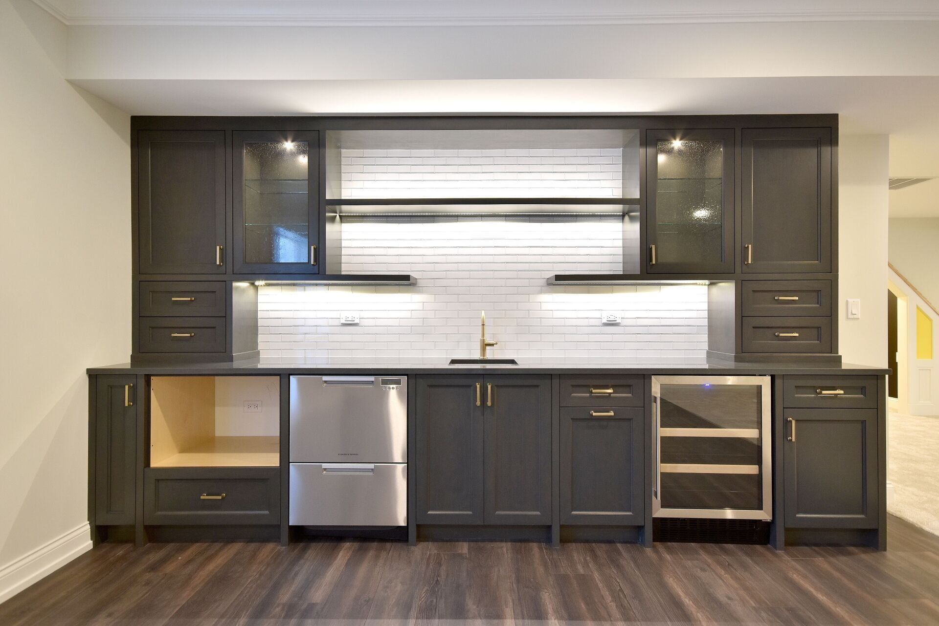 A kitchen with black cabinets and stainless steel appliances