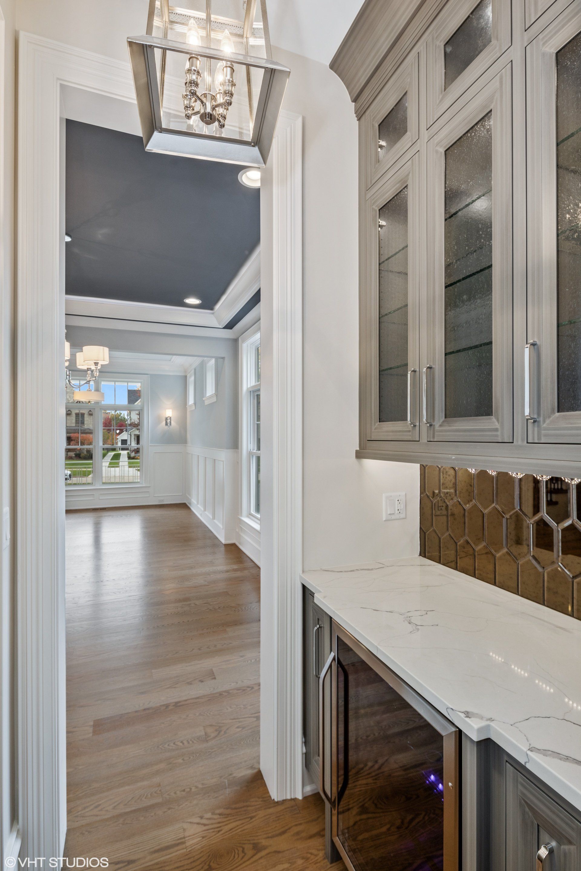 A kitchen with gray cabinets and a wine cooler.