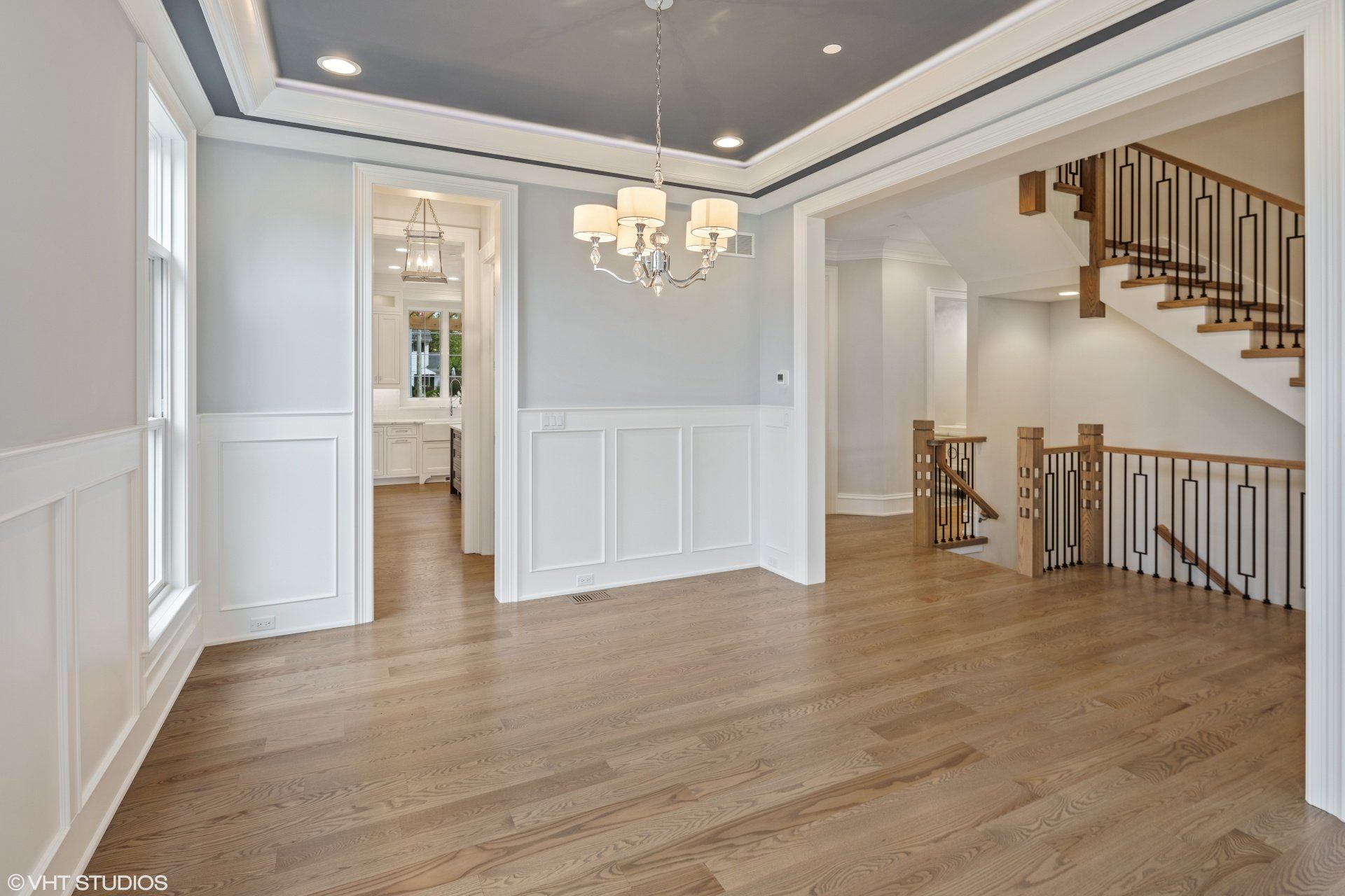 An empty room with a chandelier hanging from the ceiling.