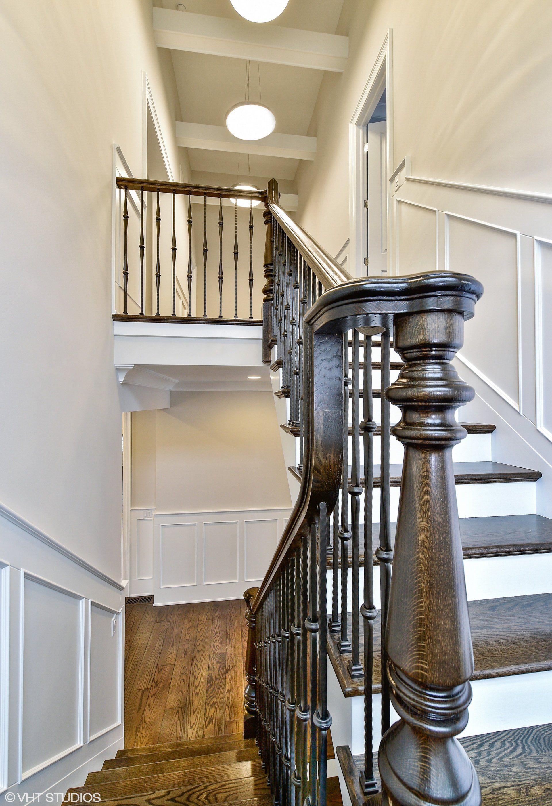 A staircase with a wooden railing and white steps in a house.