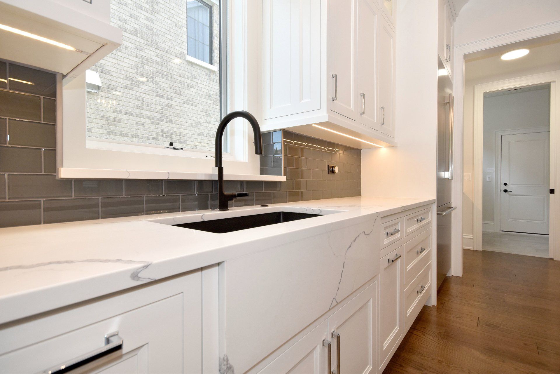 A kitchen with white cabinets and a black sink.