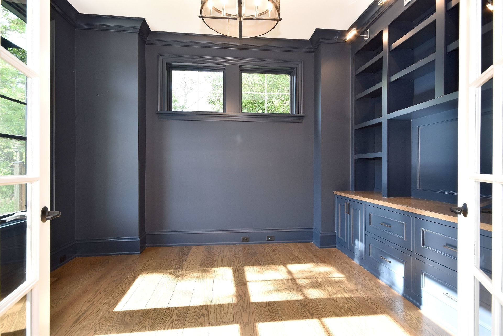 An empty room with a lot of shelves and a window.