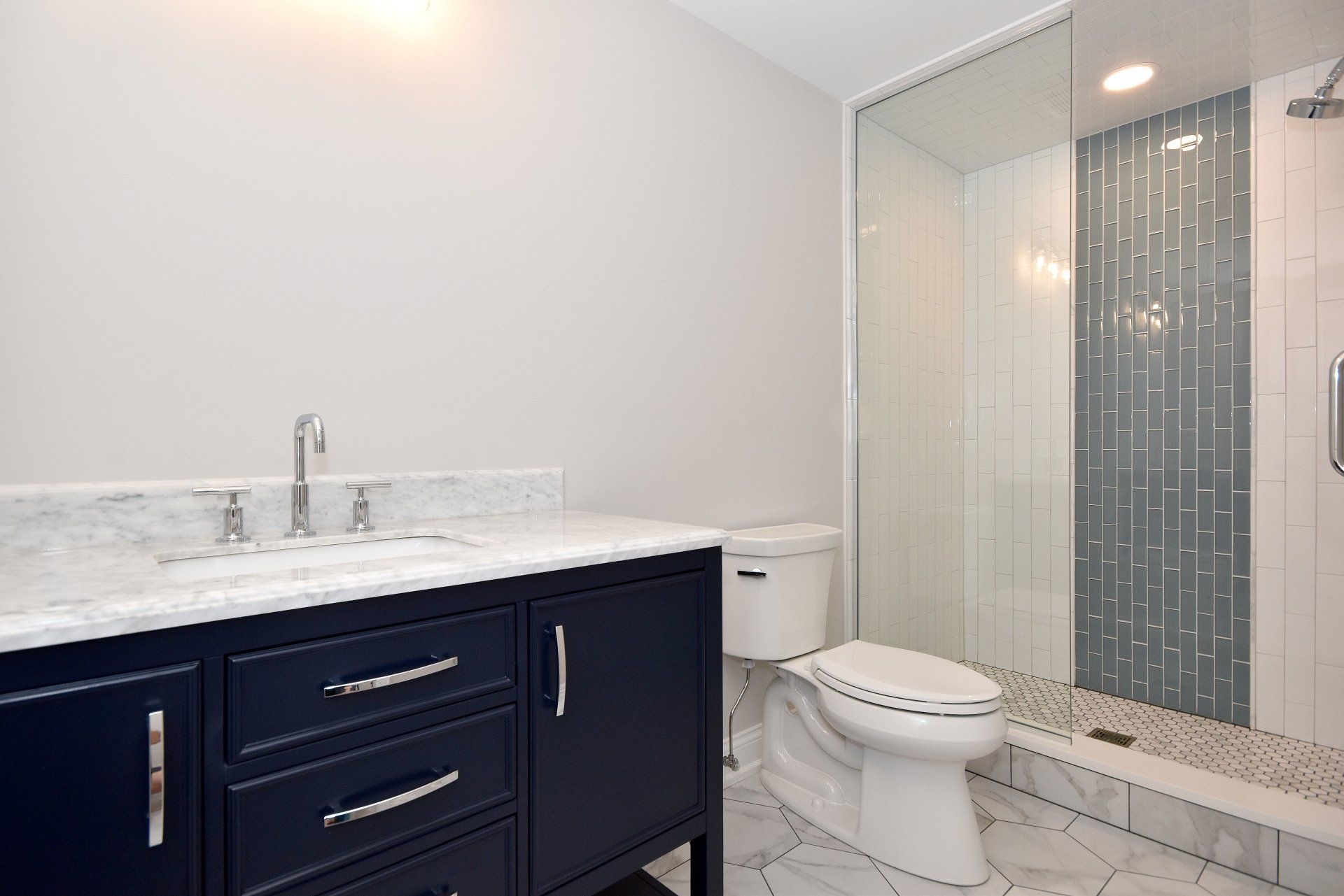 A bathroom with a toilet , sink and shower.