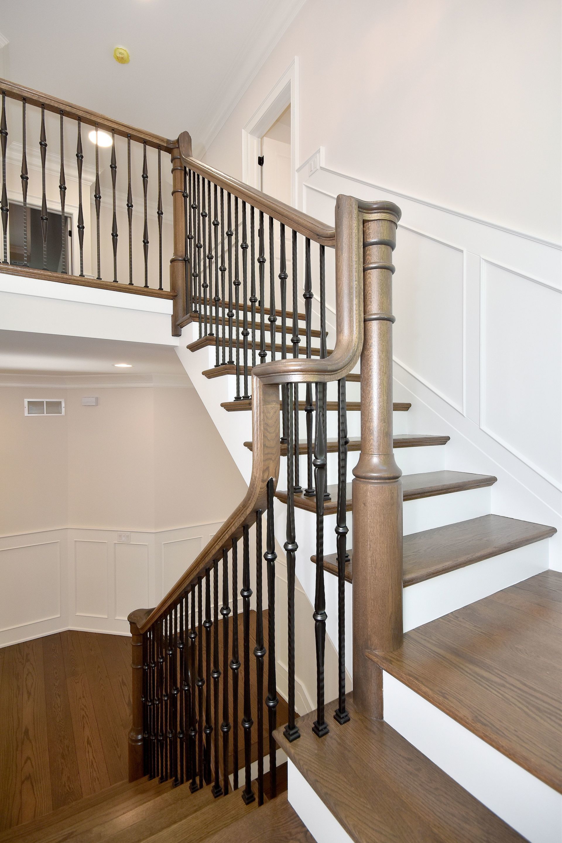 A staircase with a wooden railing and white steps in a house.