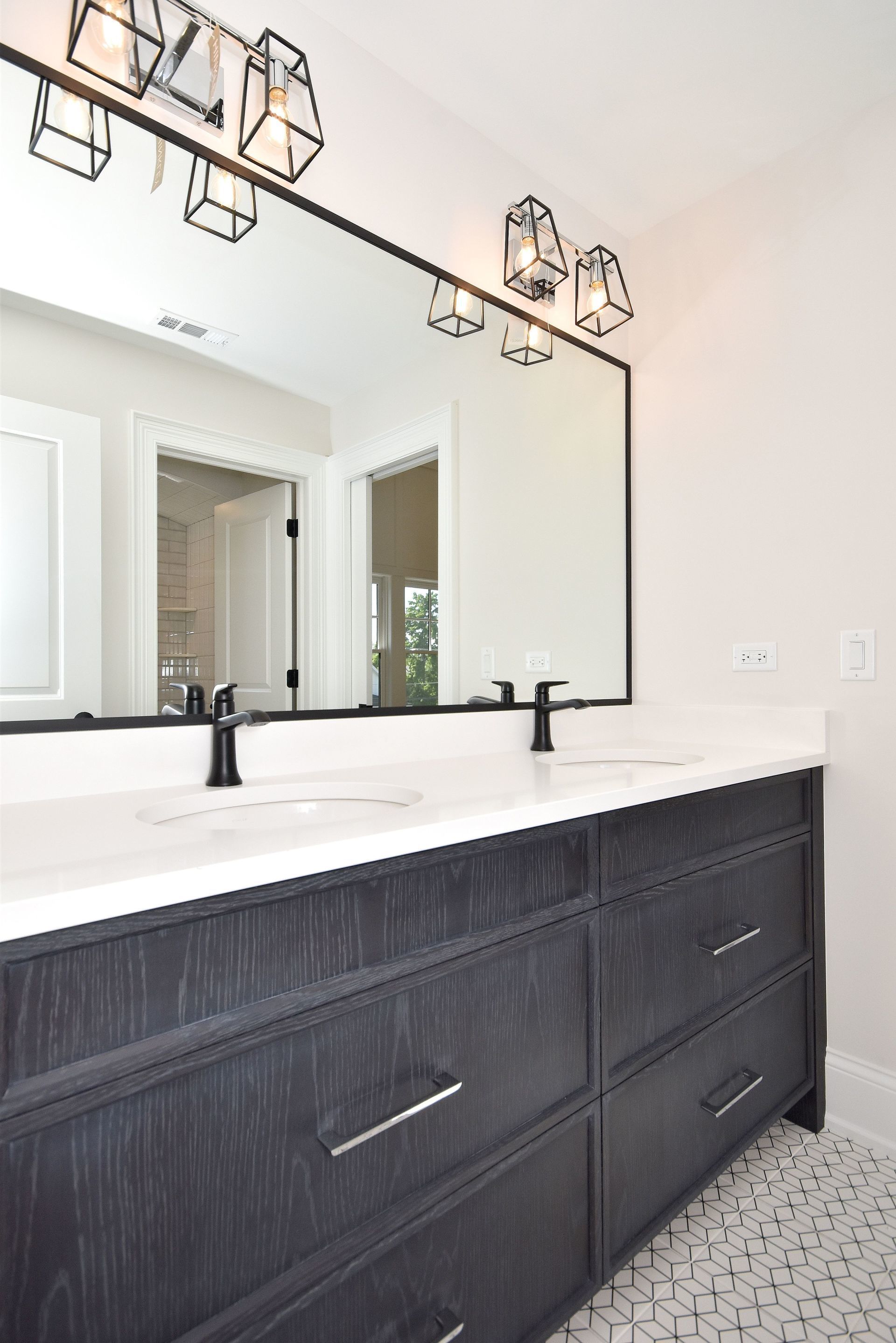 A bathroom with two sinks and a large mirror.