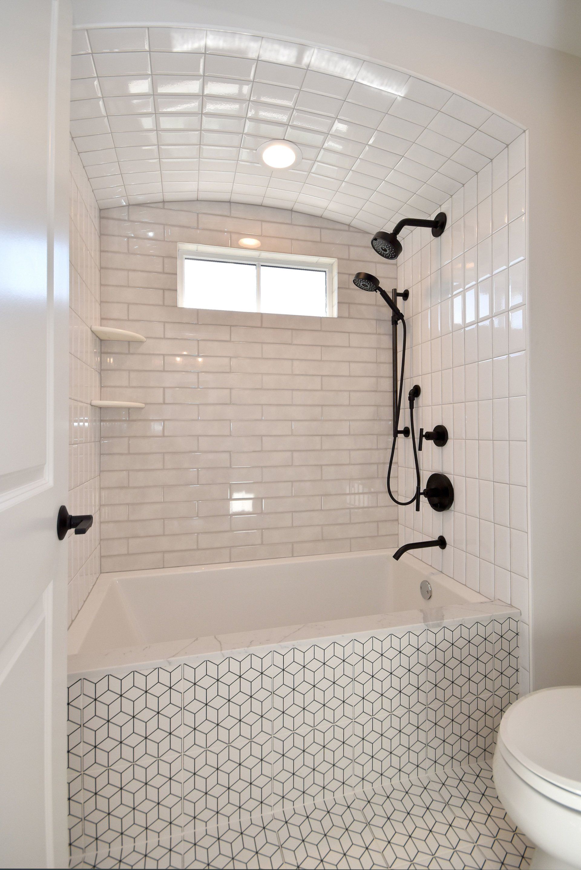 A bathroom with a tub , toilet and shower.