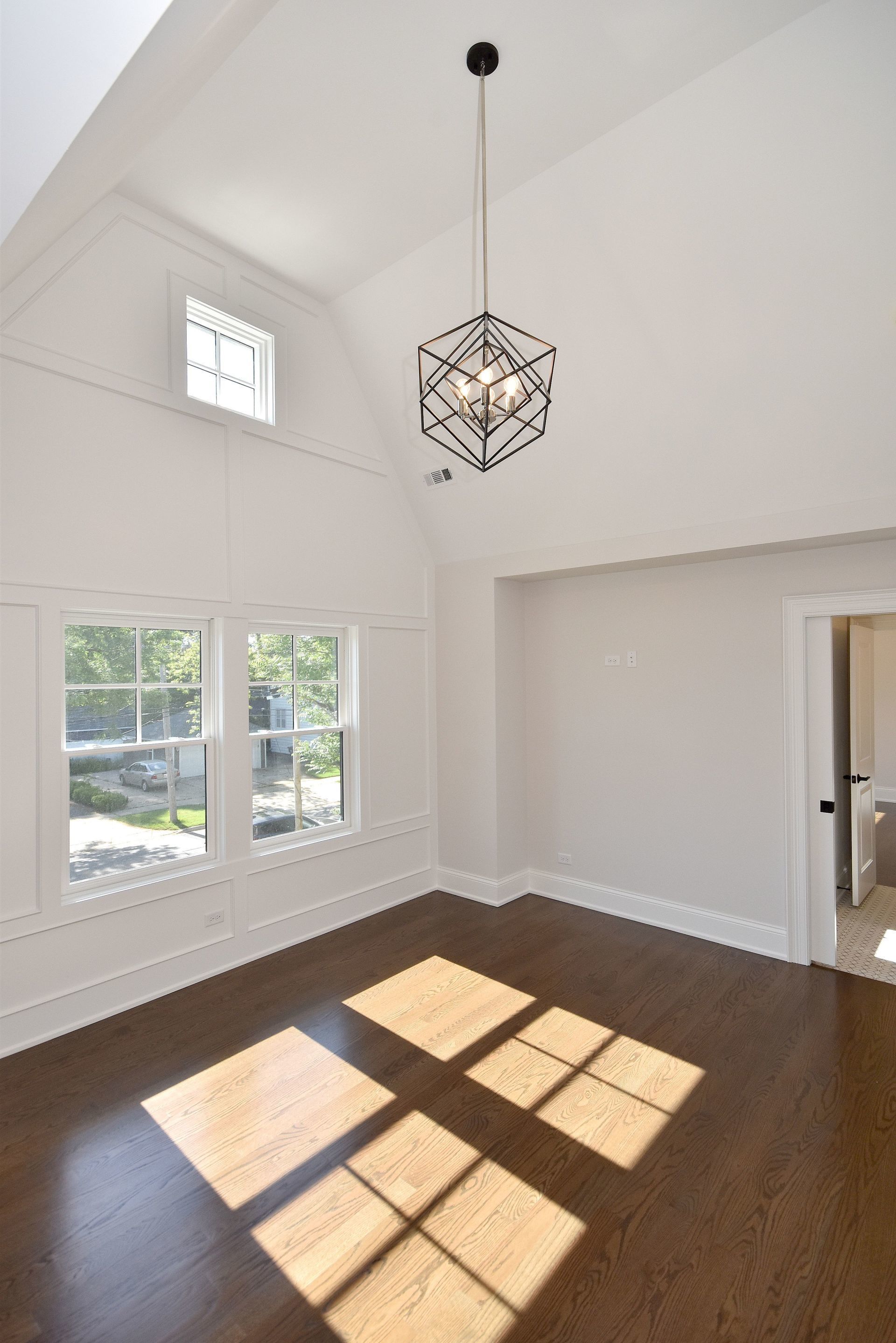 A room with a lot of windows and a chandelier hanging from the ceiling.