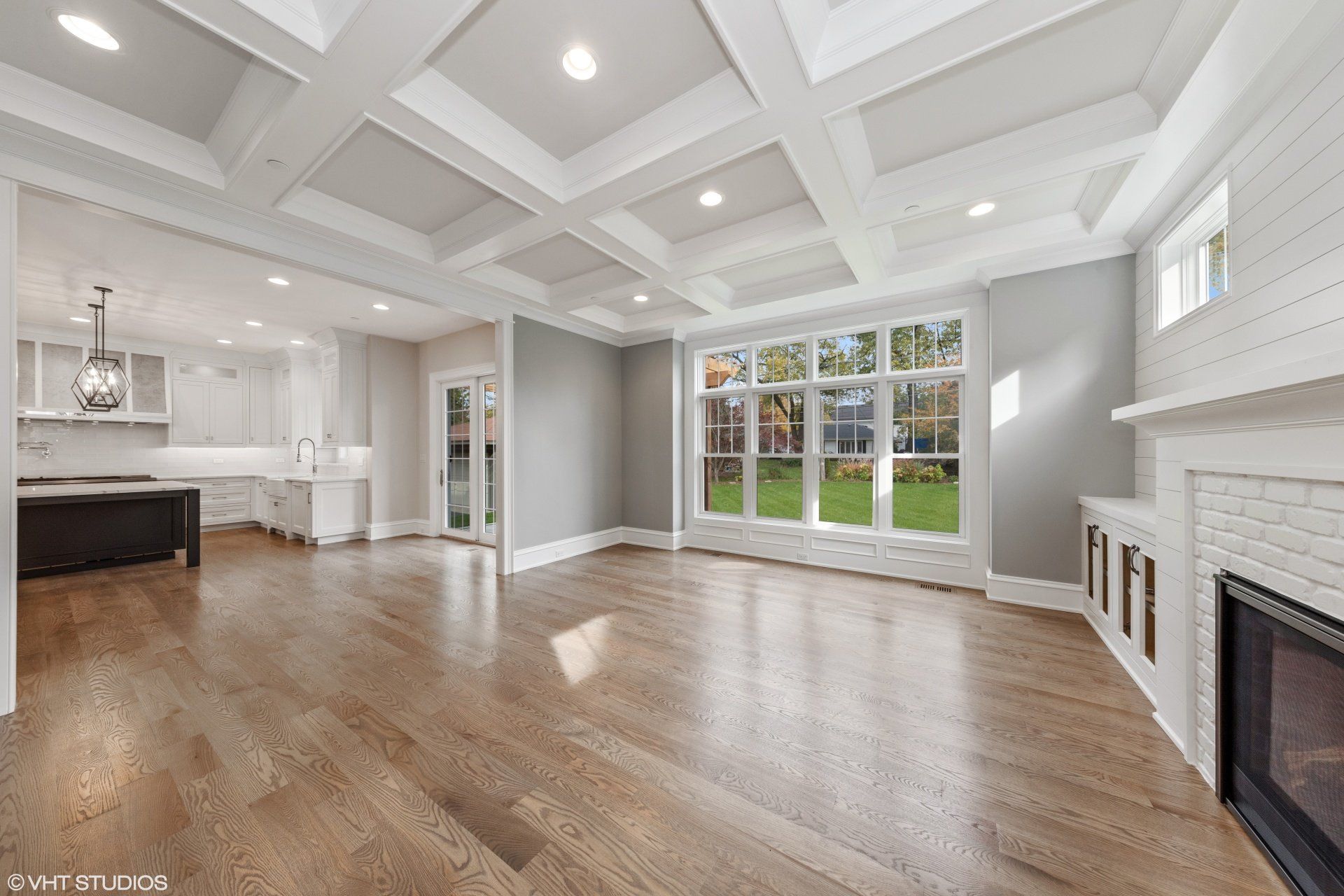 An empty living room with hardwood floors and a fireplace.