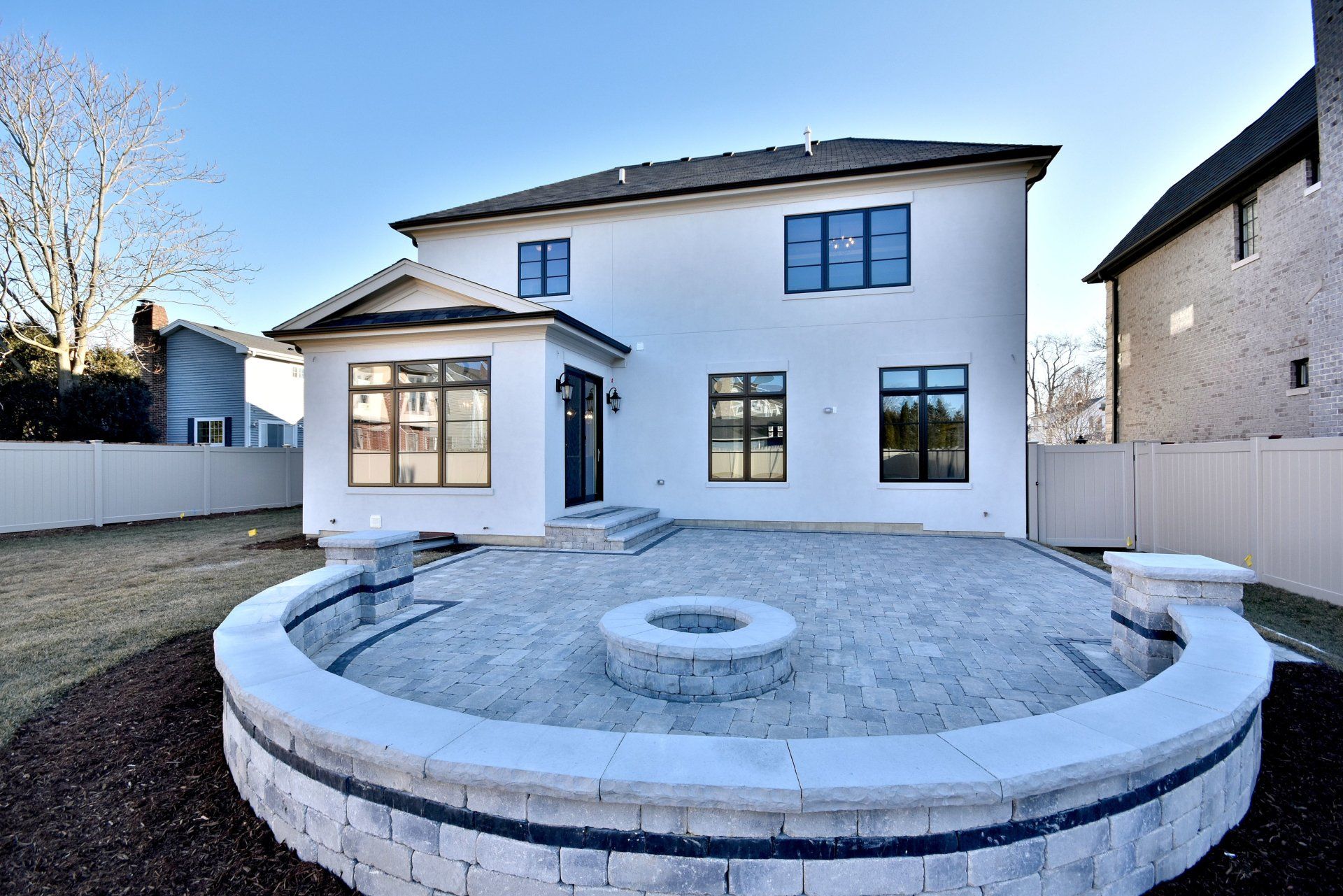 A white house with a fire pit in the backyard