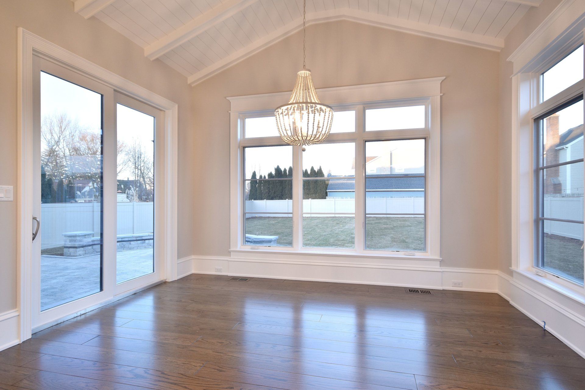 An empty room with lots of windows and a chandelier