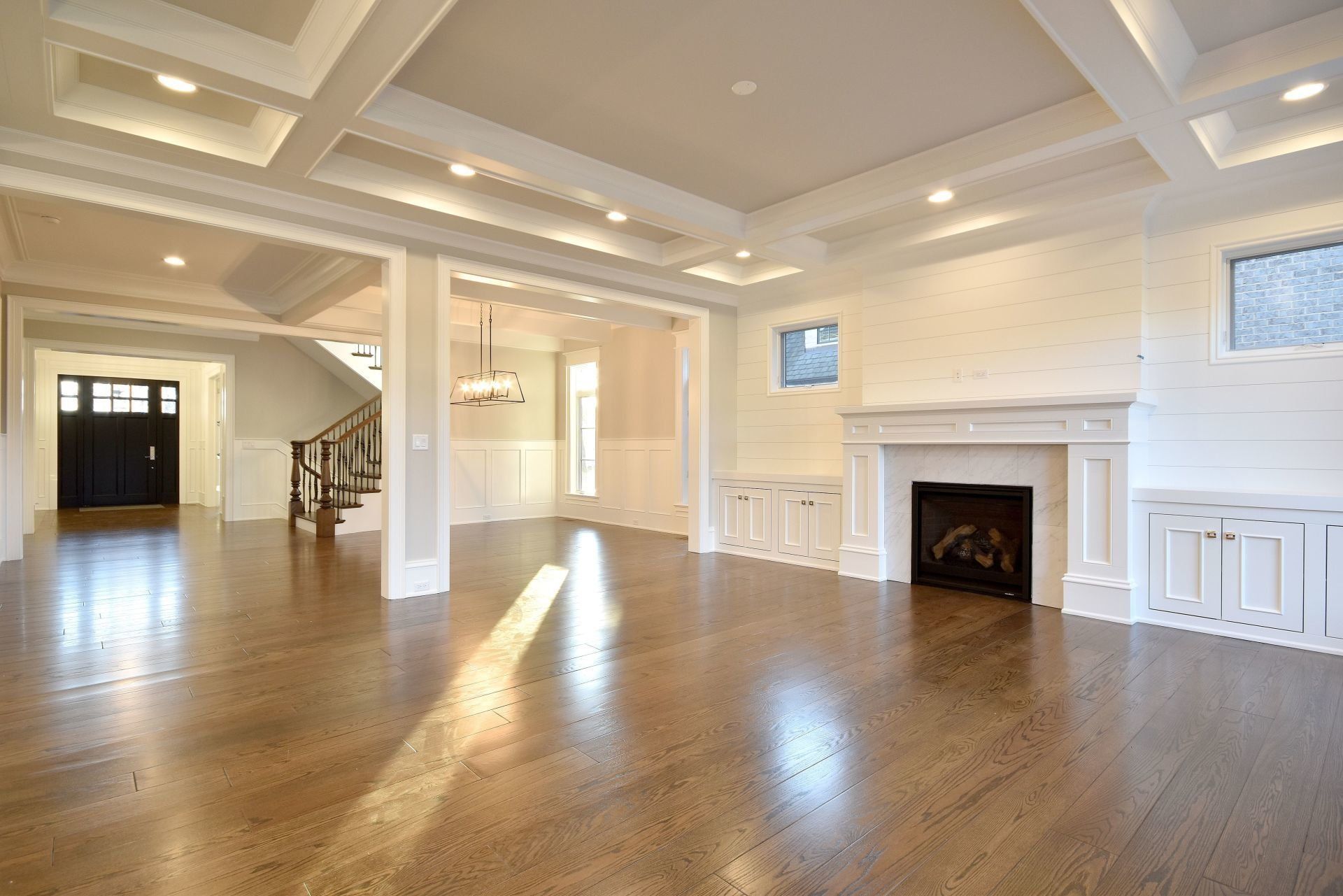 An empty living room with hardwood floors and a fireplace.