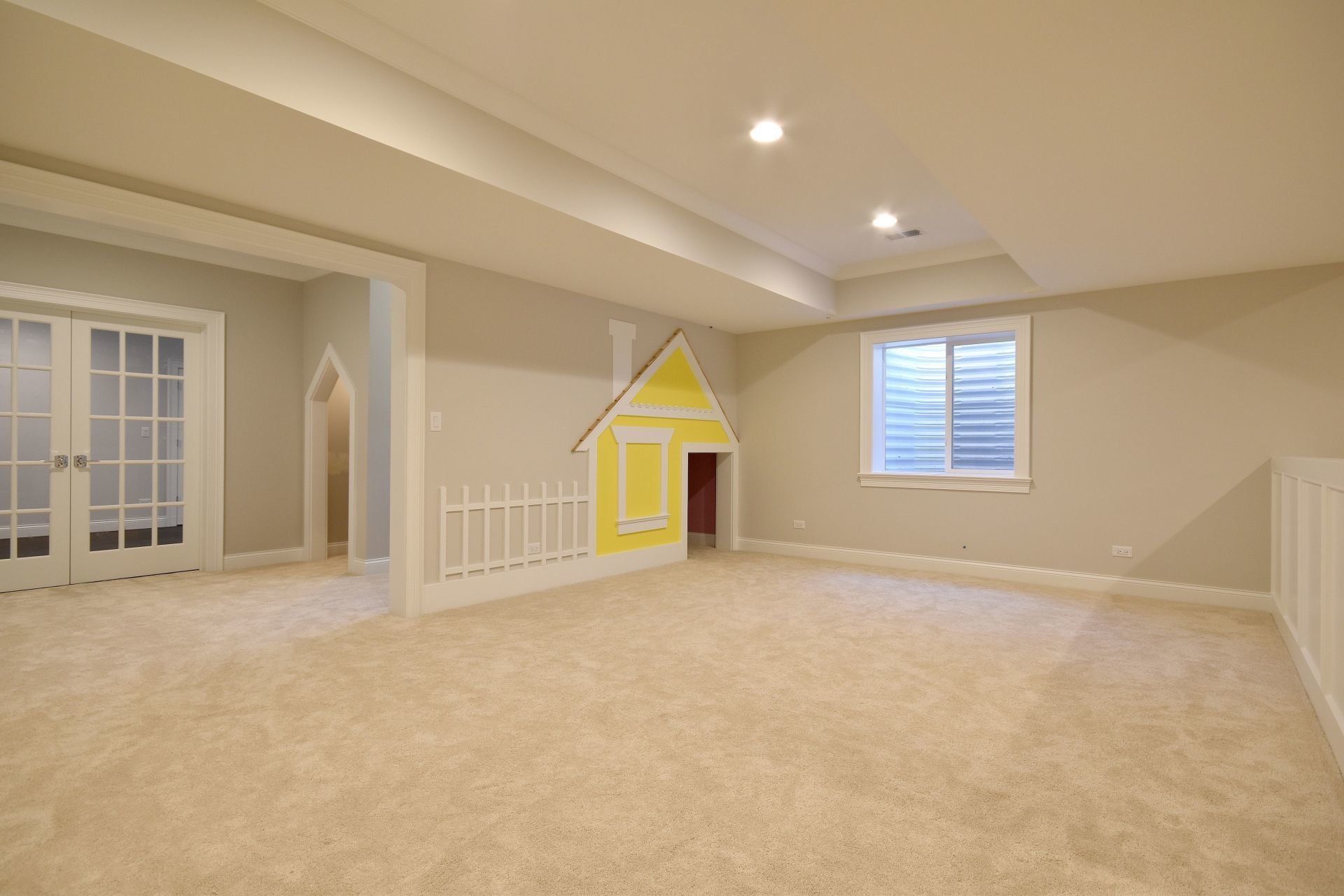 An empty room with a yellow house on the wall.