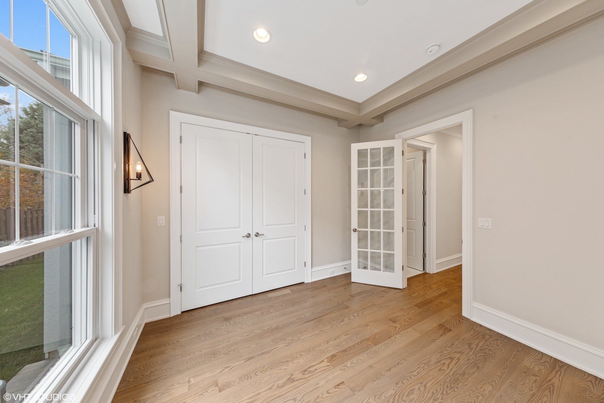 An empty room with hardwood floors and a window.
