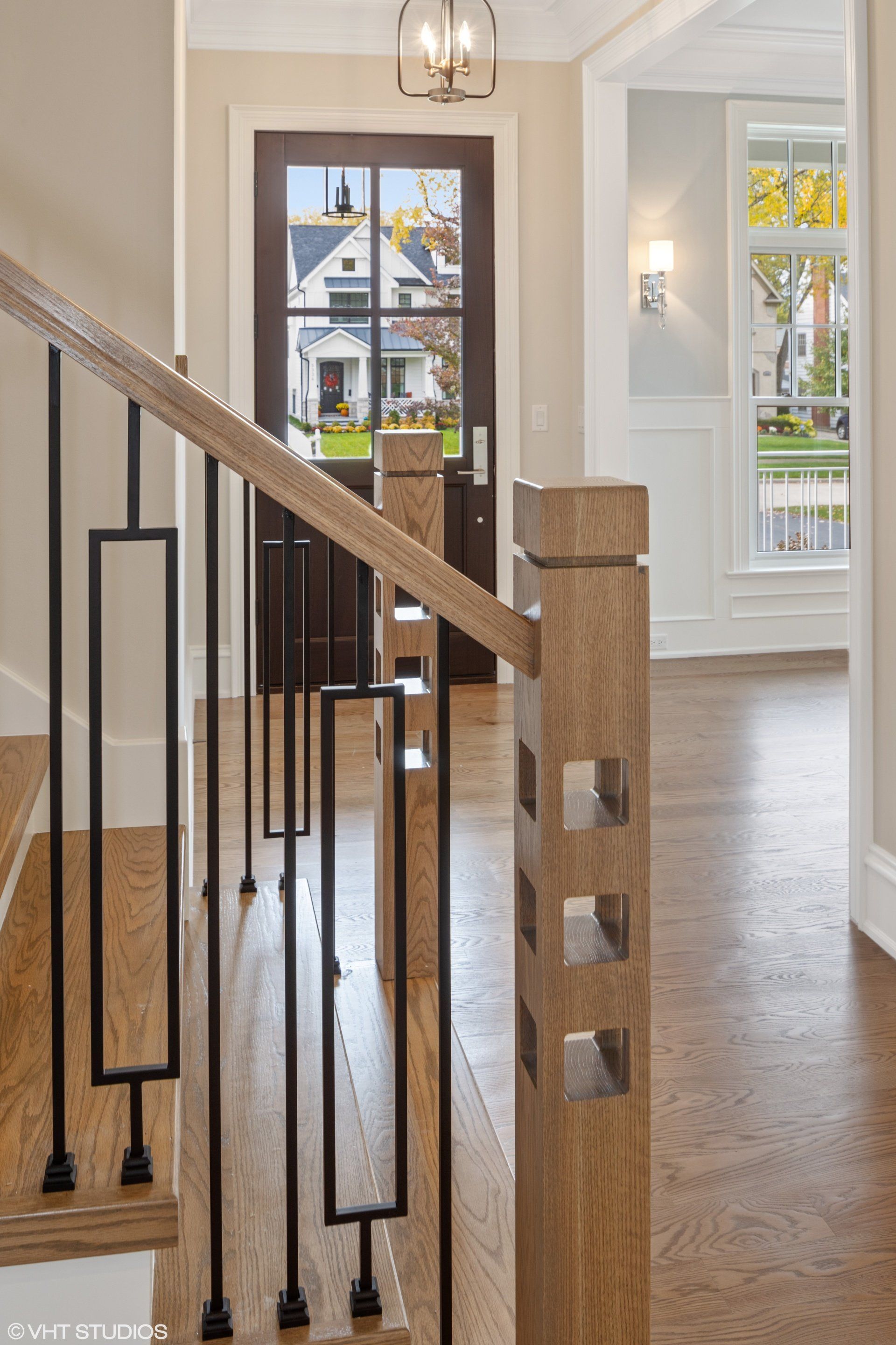 A staircase with a wooden railing and a black railing in a house.