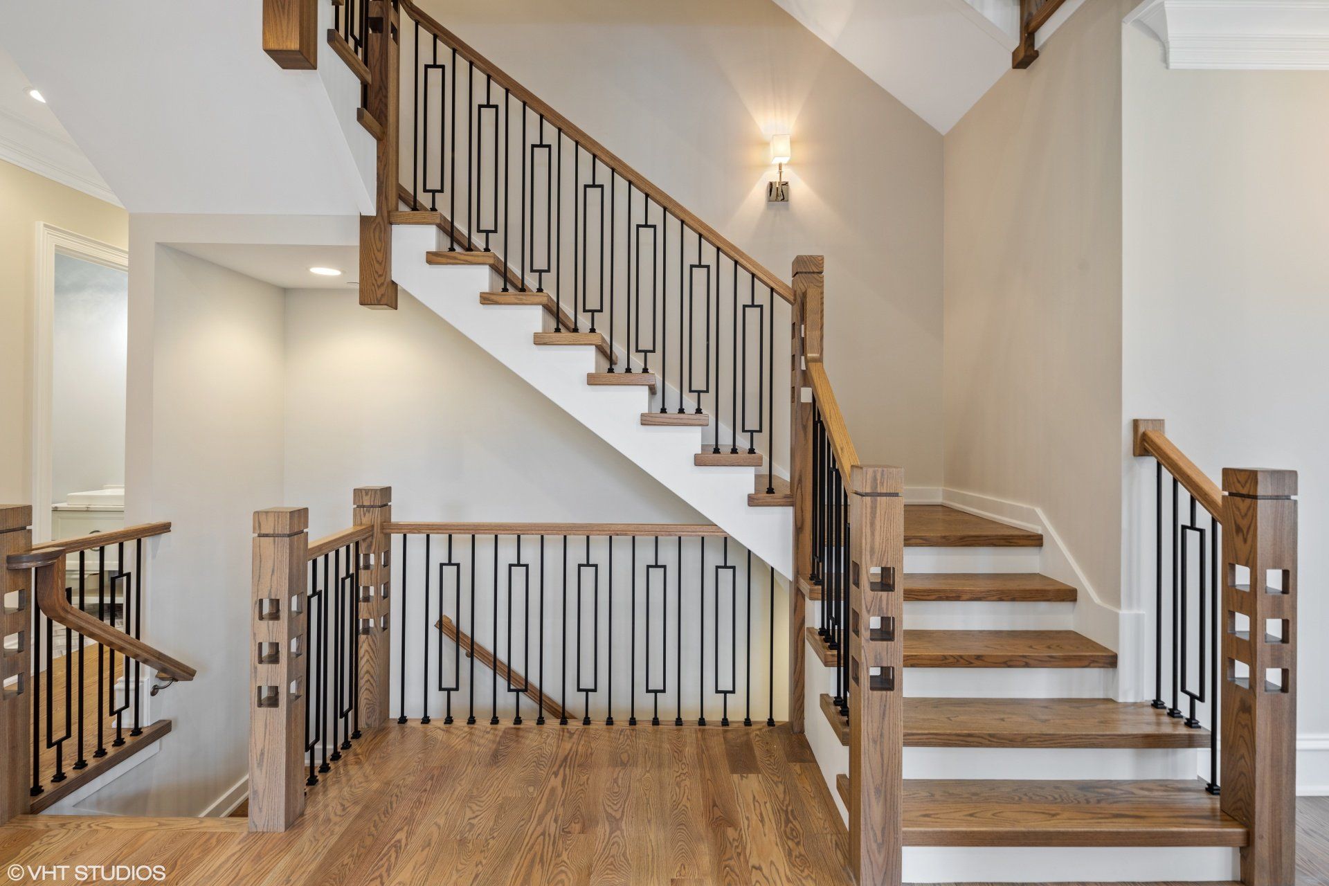 A wooden staircase with a metal railing in a house.