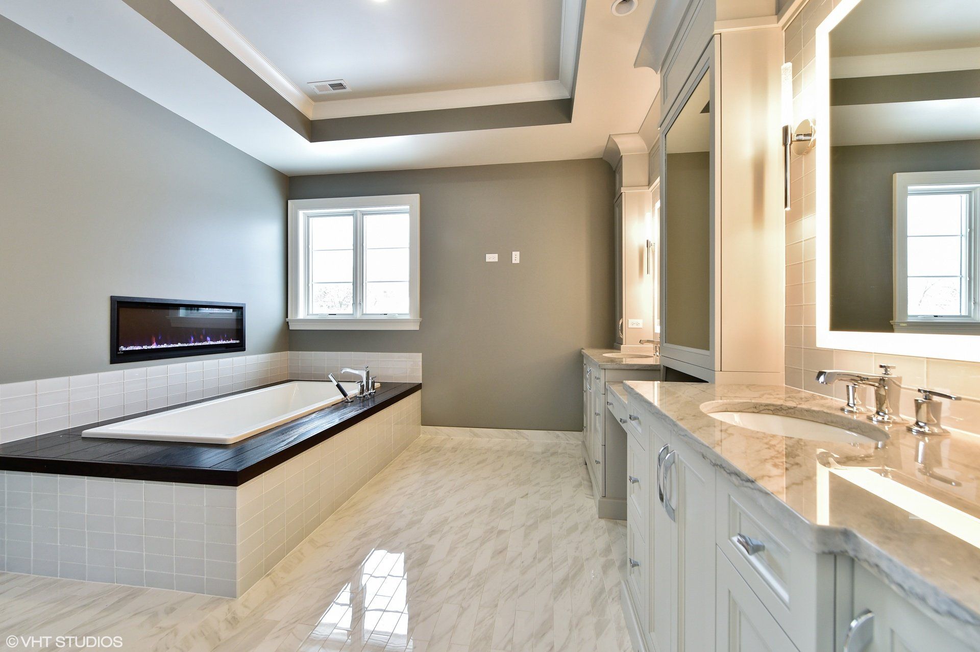 A bathroom with a tub , sinks and mirrors